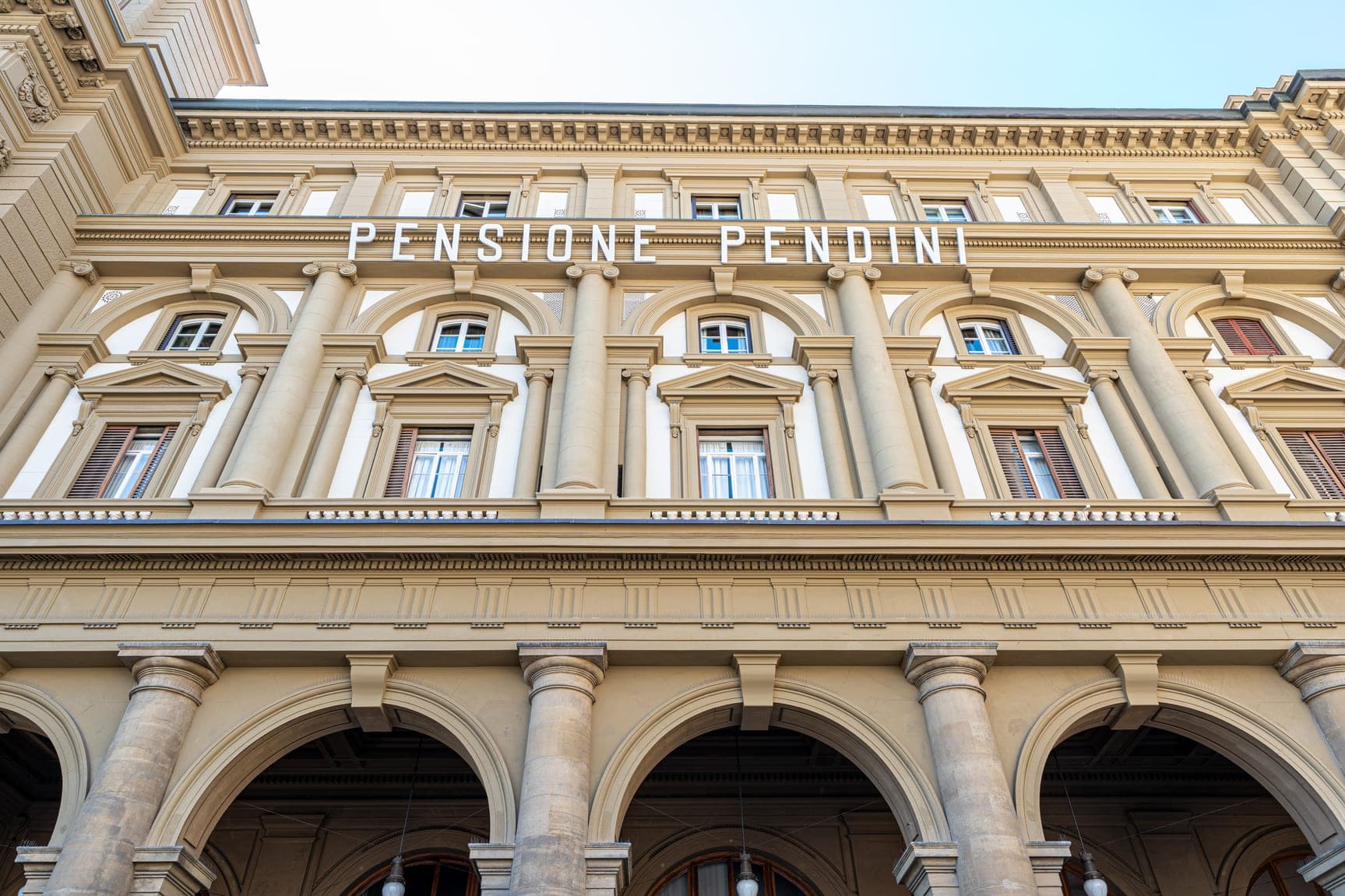 Exterior of Hotel Pendini with arched windows and columns.