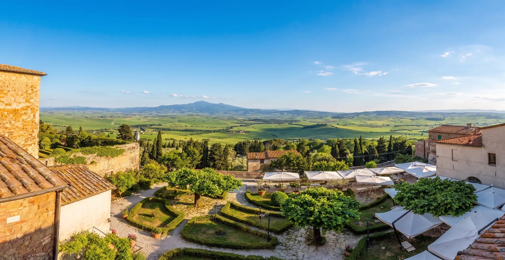 View of the Tuscan countryside with gardens and outdoor seating from a venue.