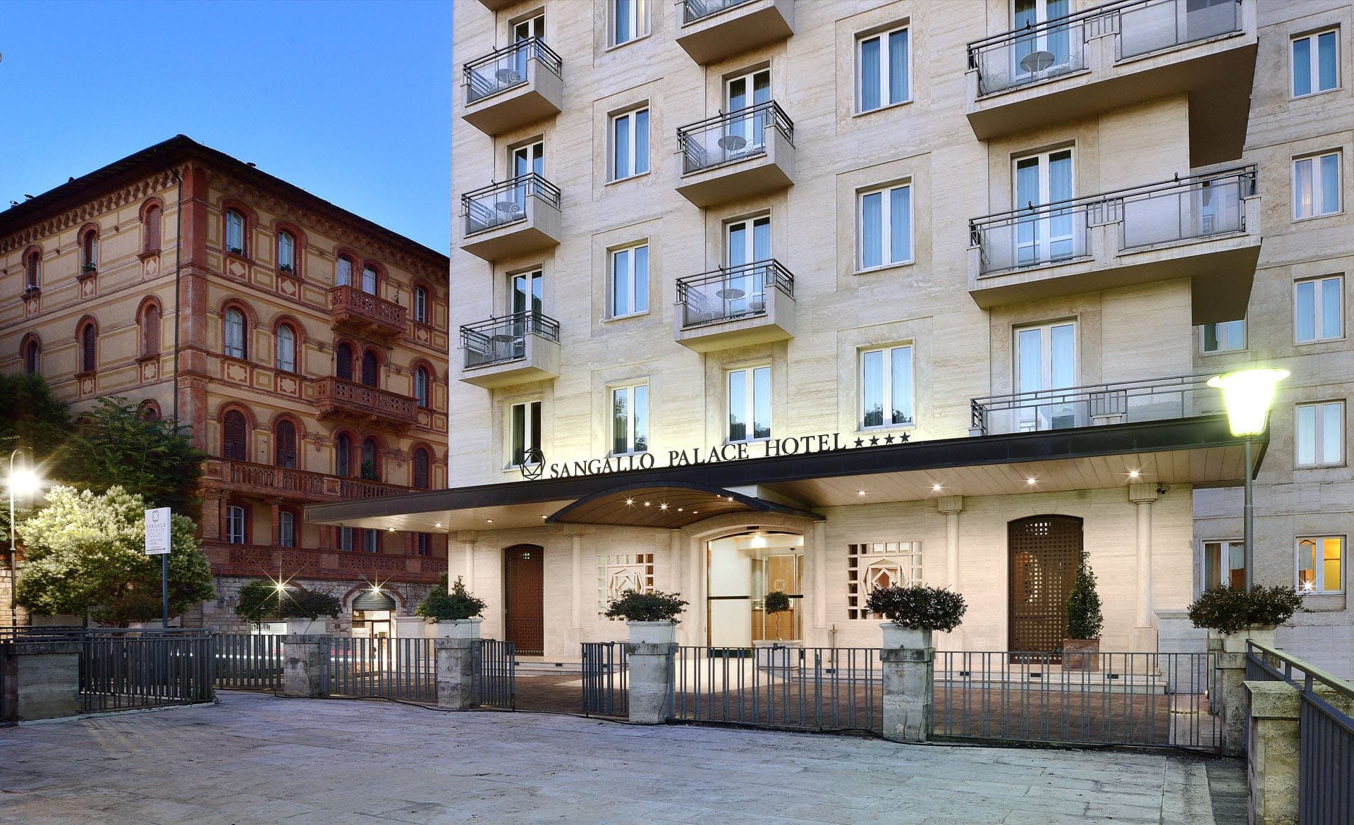 Exterior of the Sangallo Palace Hotel with its entrance and balconies.