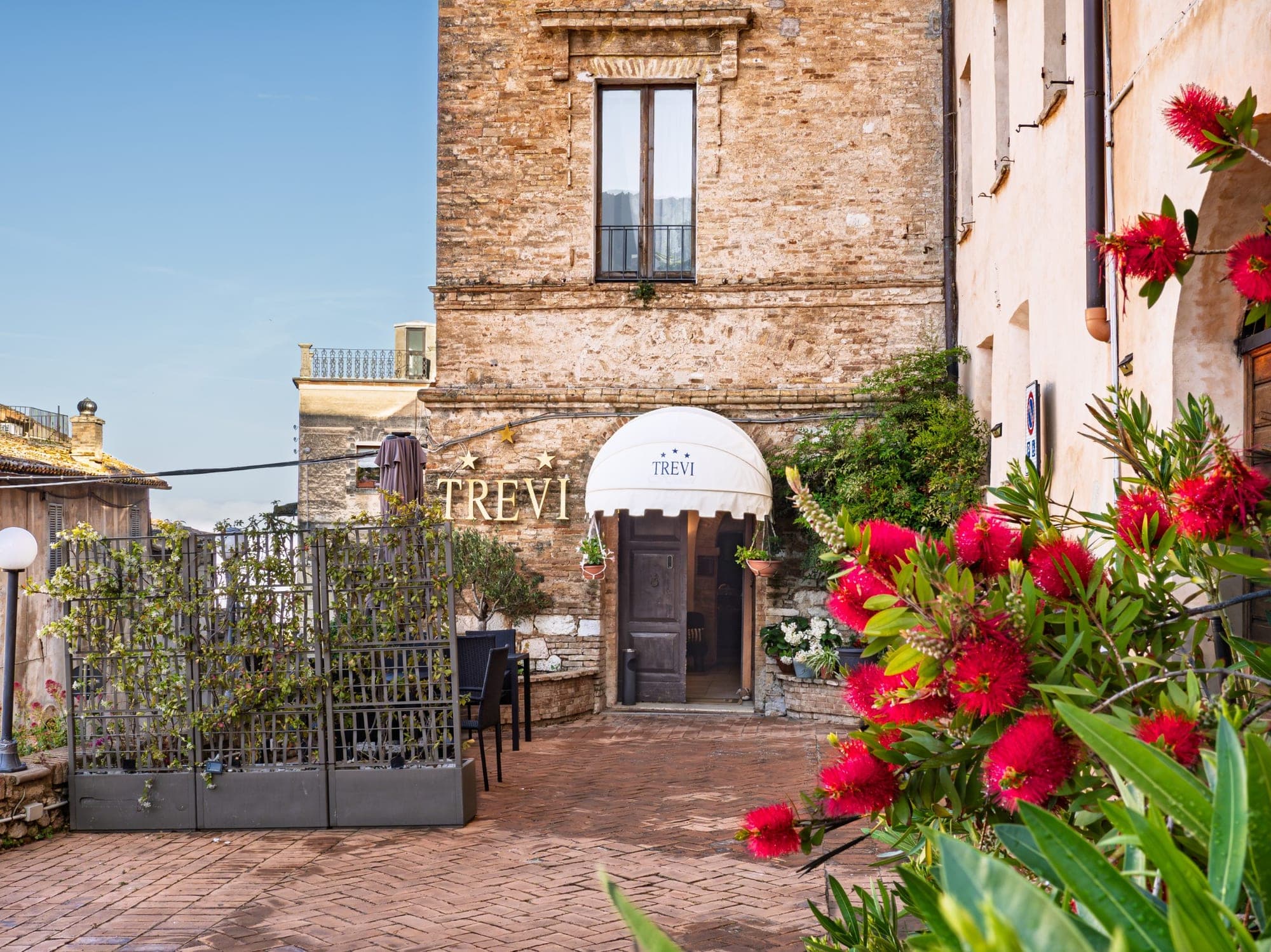 Entrance to Hotel Trevi with red flowers in the foreground.