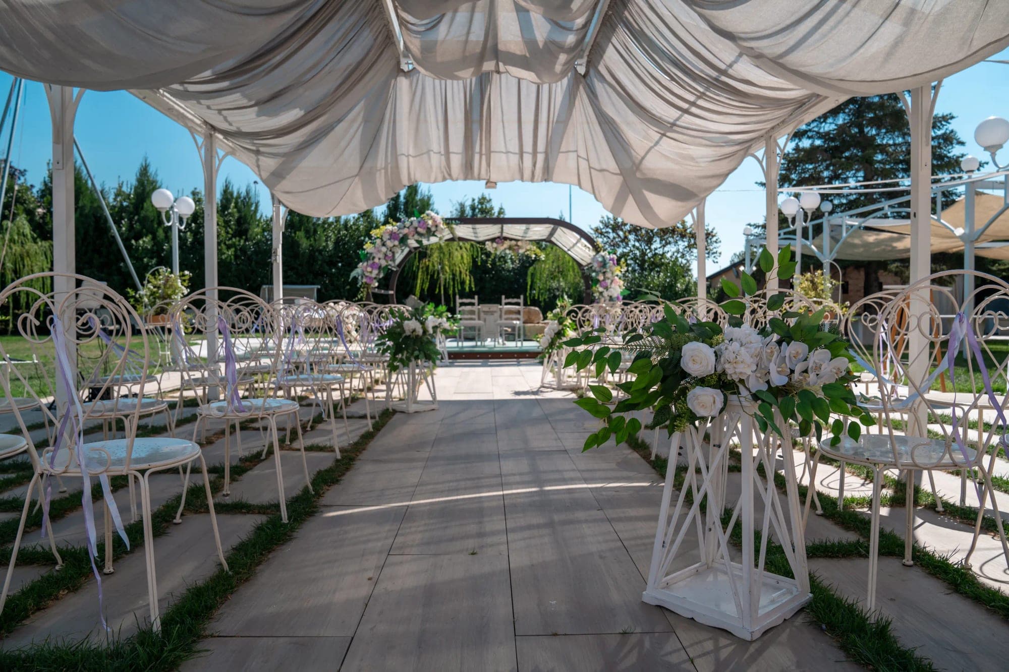 Outdoor wedding ceremony setup with rows of chairs and floral decorations.