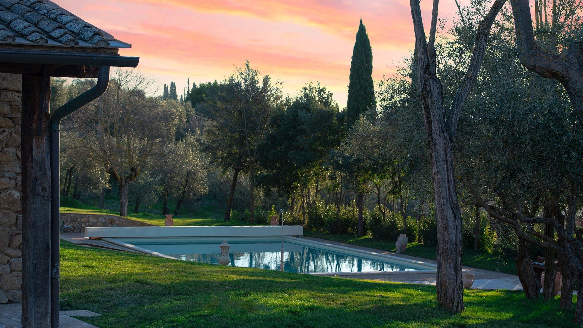 Swimming pool and grounds of a wedding venue at sunset.