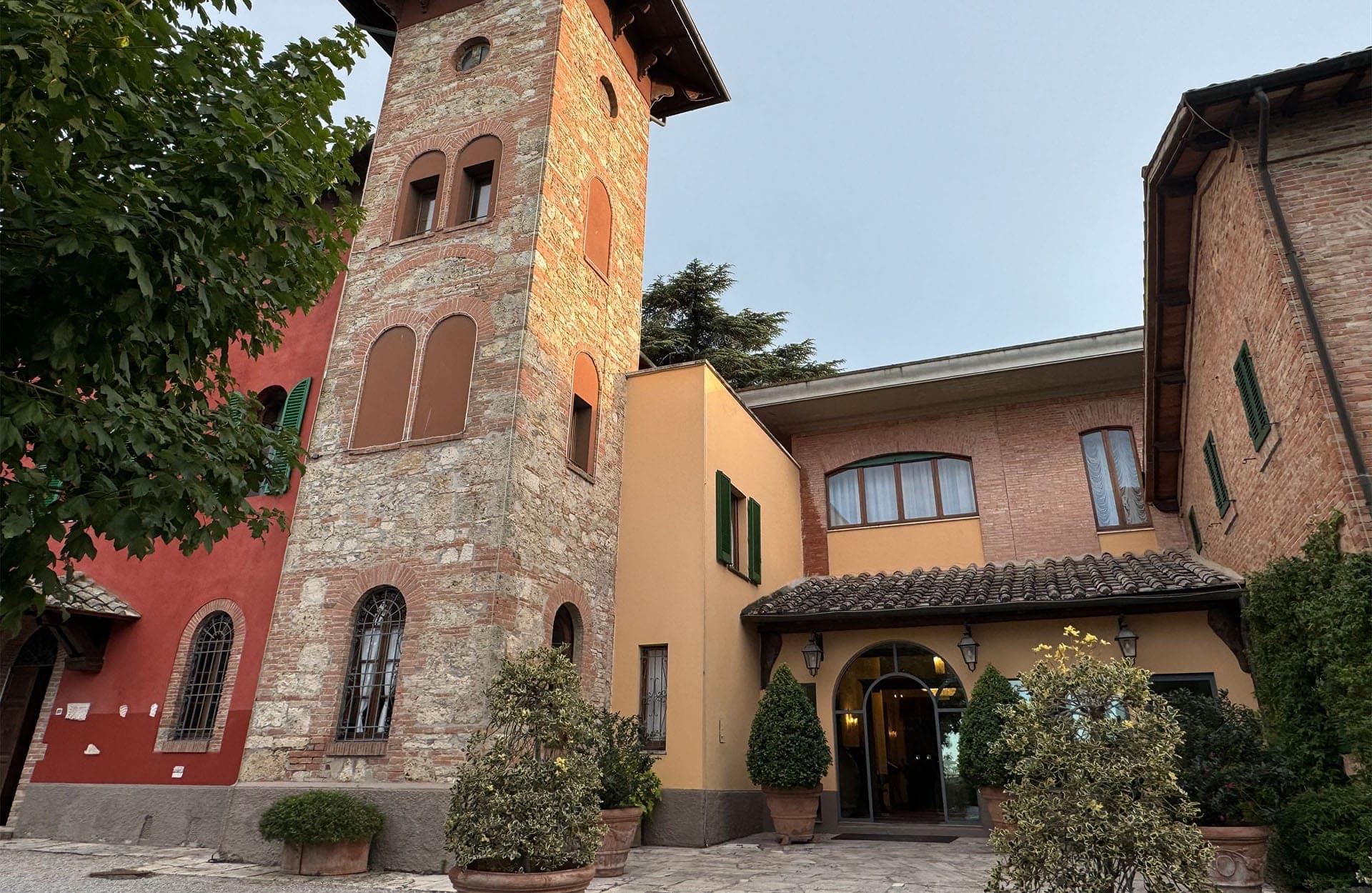 Exterior of a wedding venue with a stone tower and red brick buildings.