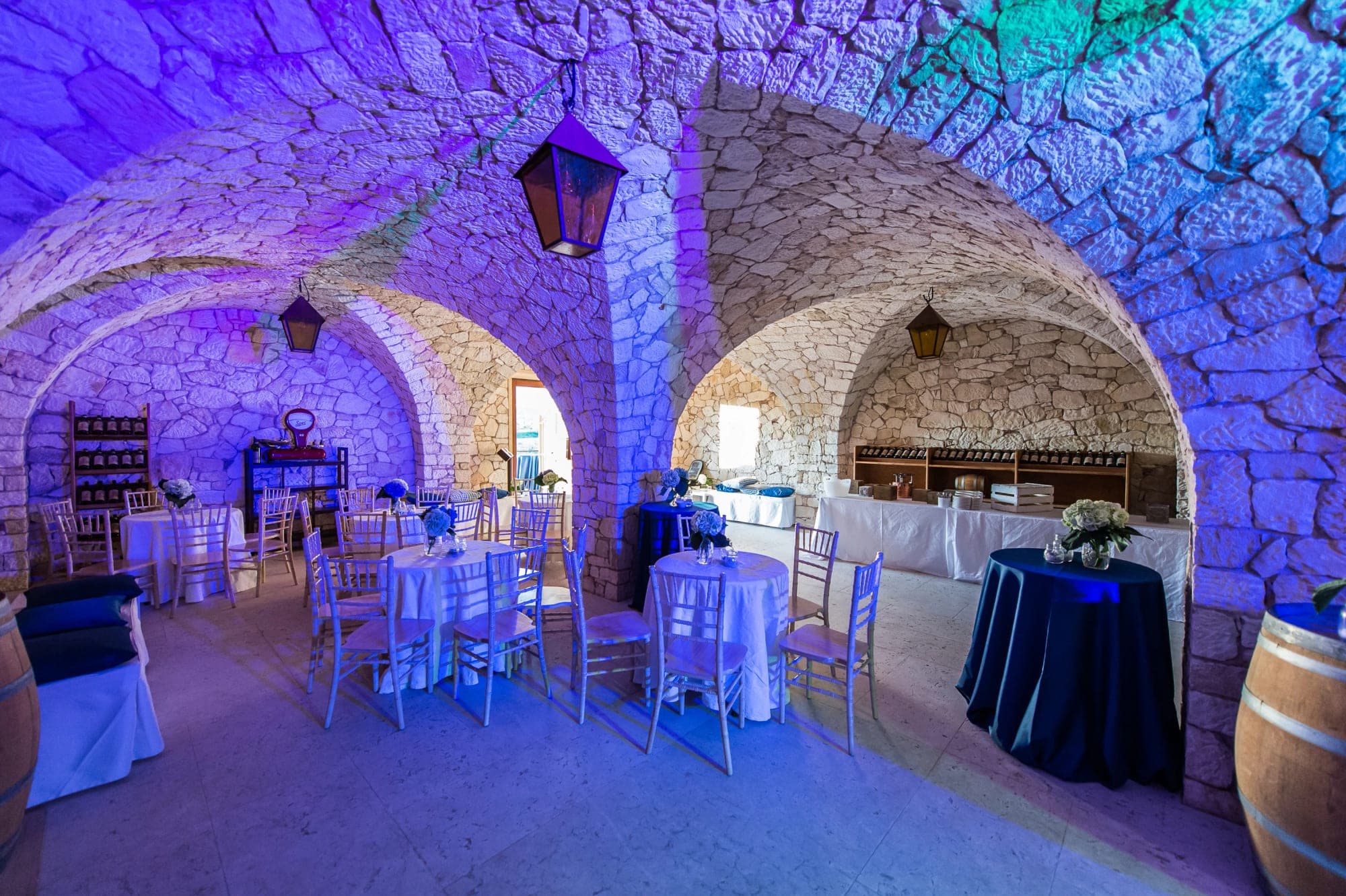 Reception area with stone arches and tables set for guests.