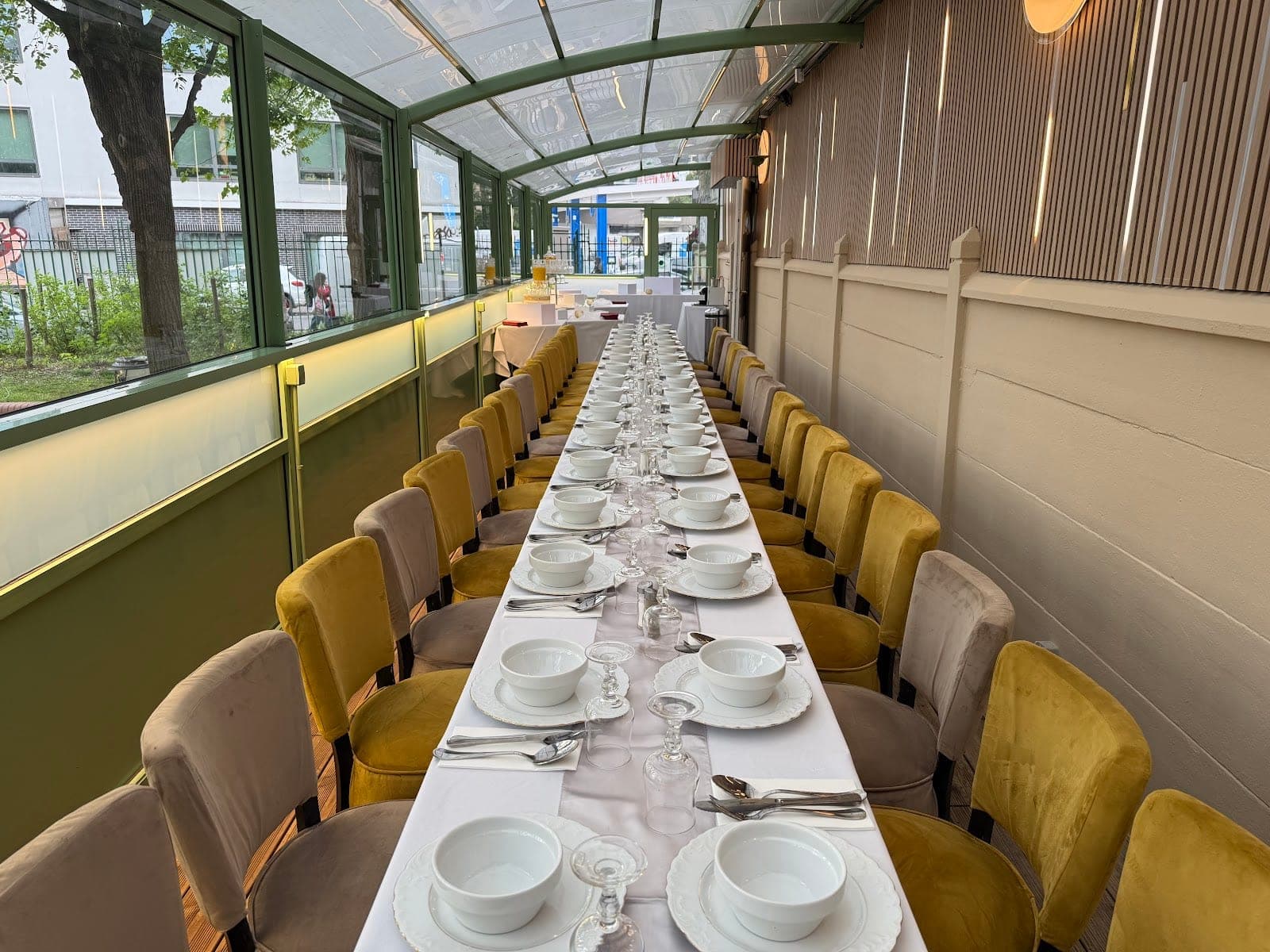 A long dining table set for a reception in a conservatory.