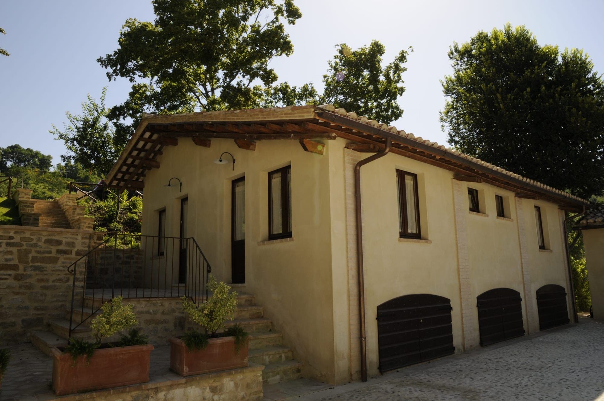Exterior of a building with garage doors and a stone staircase.