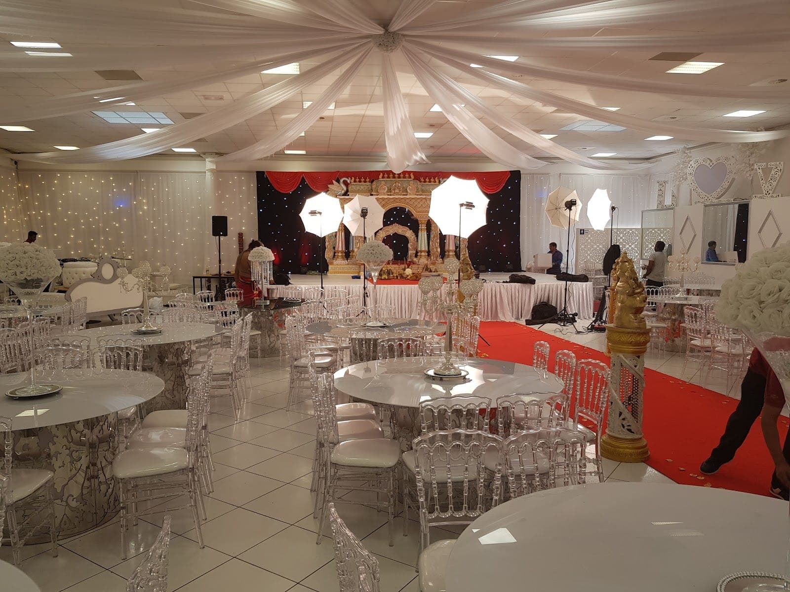 A decorated reception hall with tables and chairs set up for an event.