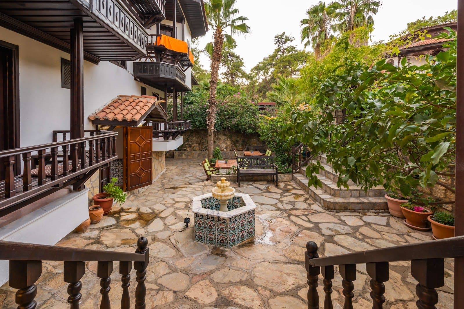 Courtyard with a fountain, seating, and greenery at a hotel.
