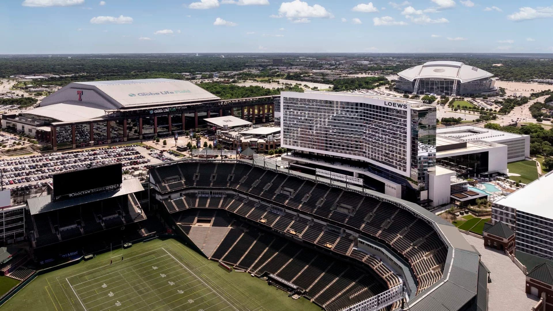 Aerial view of Loews hotel and sports stadiums under a blue sky.