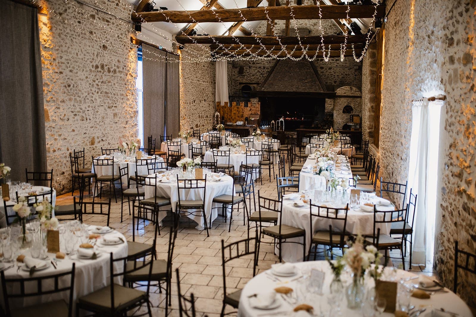A wedding reception room with round tables set for dinner.
