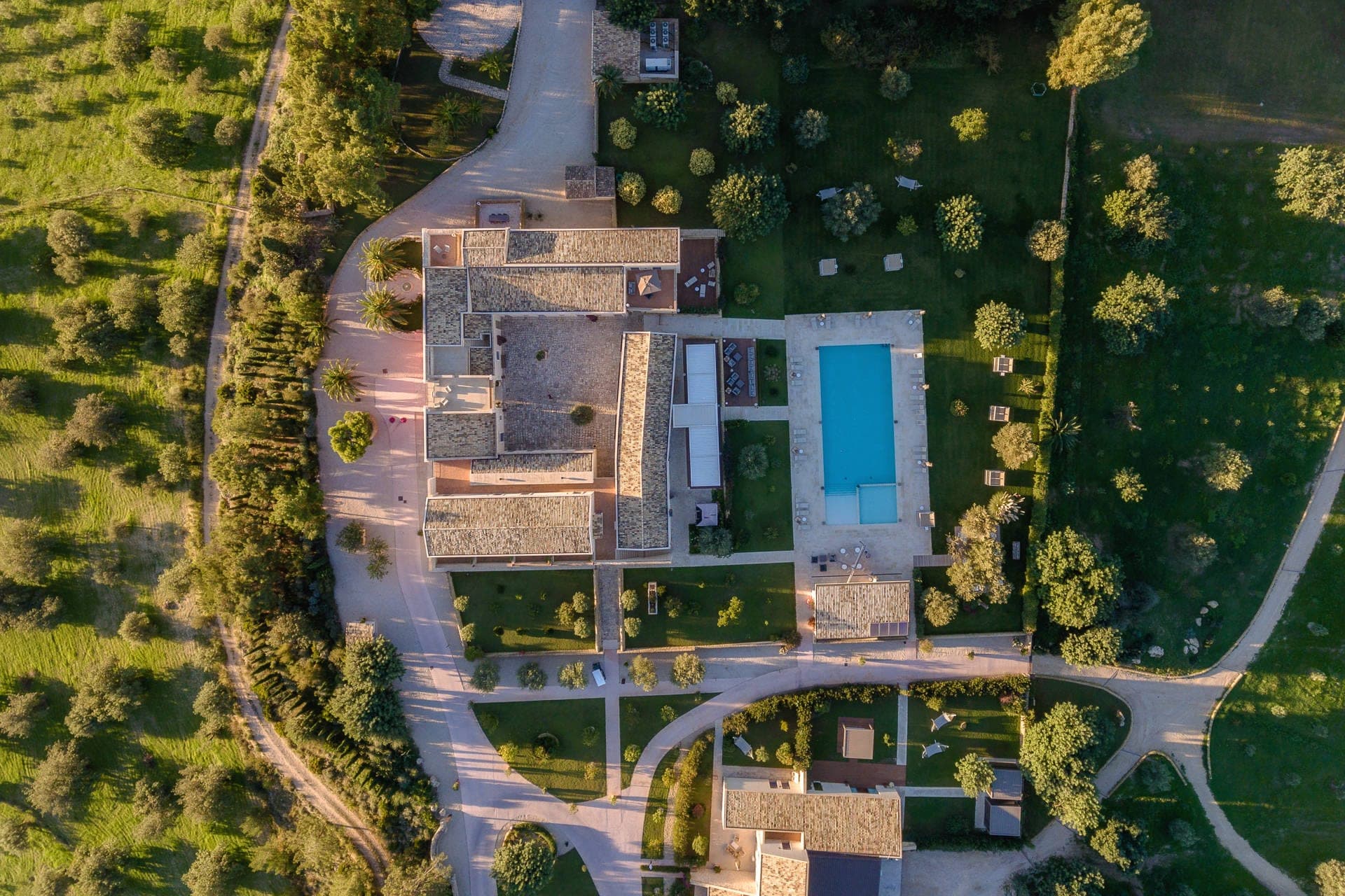 Aerial view of a wedding venue with buildings and a swimming pool.