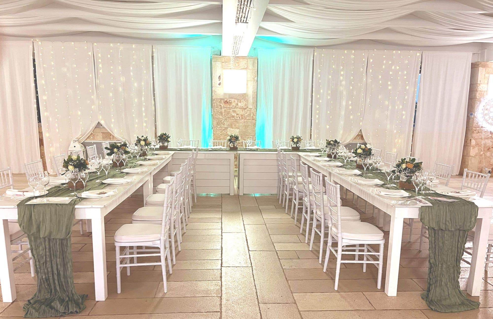 A reception hall with long tables set for a wedding meal.
