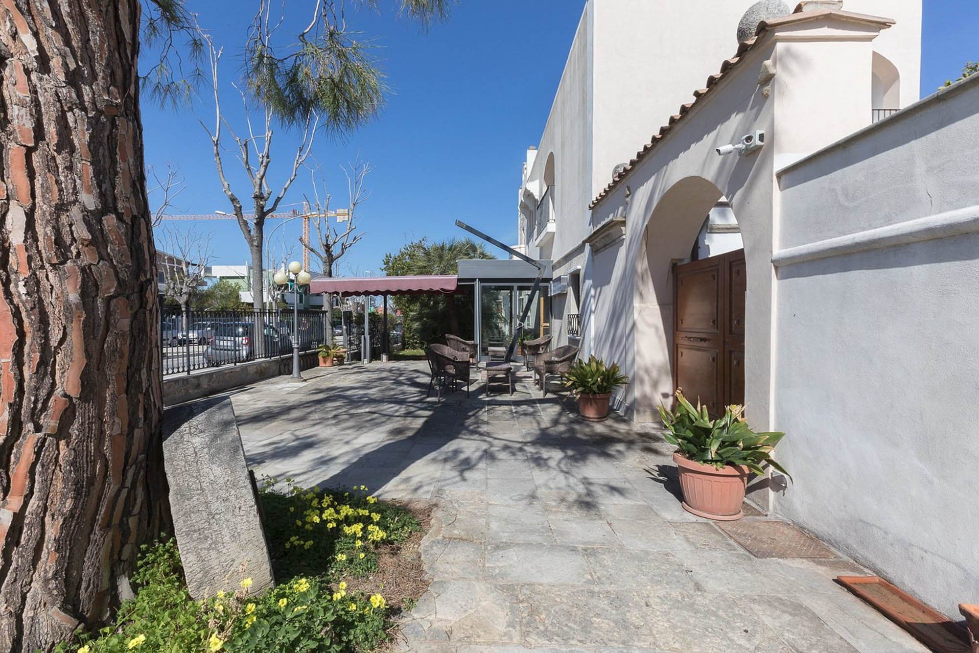 Outdoor seating area with tables and chairs next to a building.