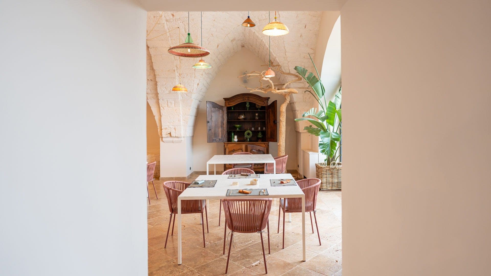 Dining area with tables, chairs, and a vintage cabinet.
