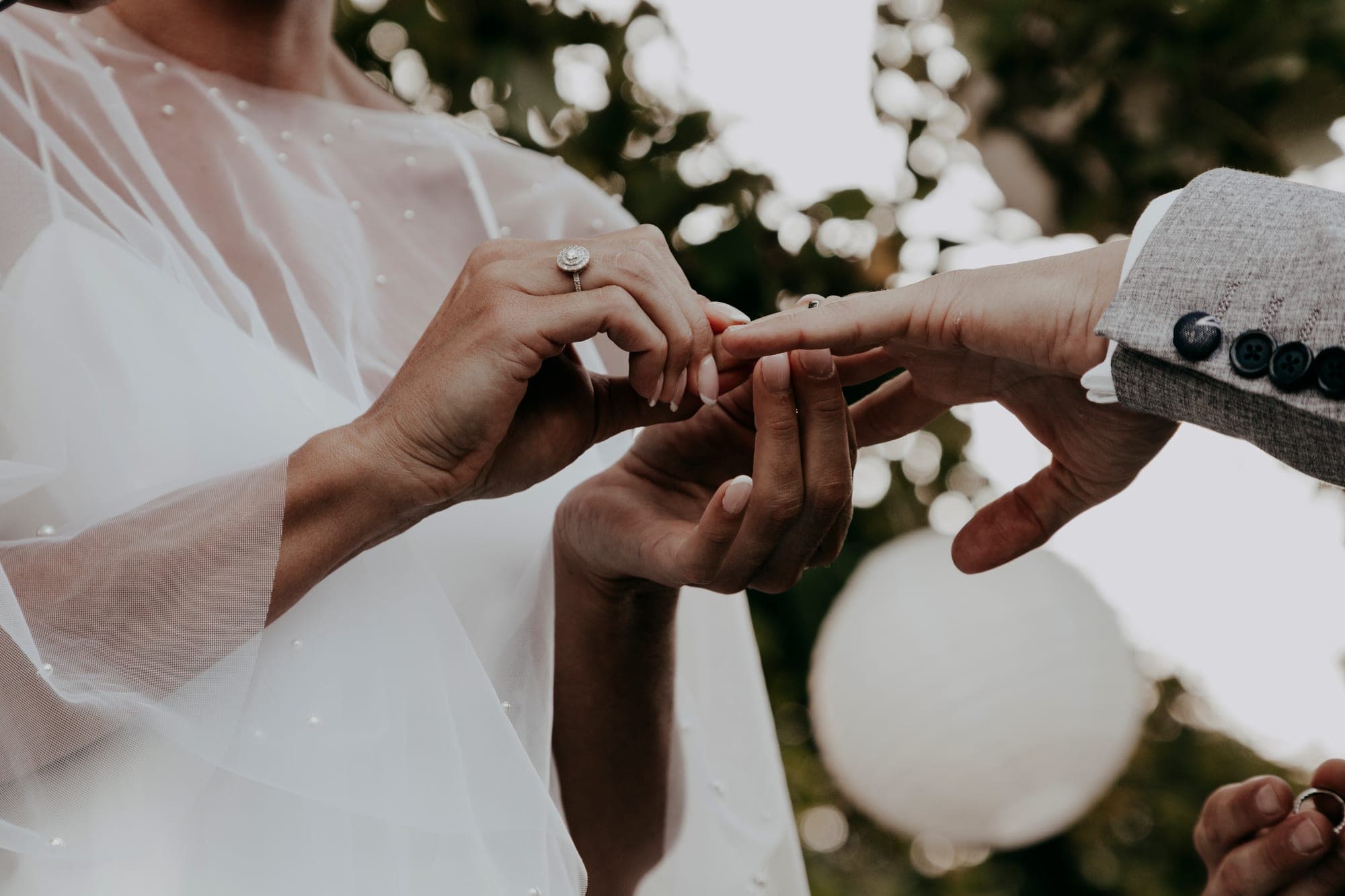 A bride places a ring on a groom's finger during a wedding ceremony.