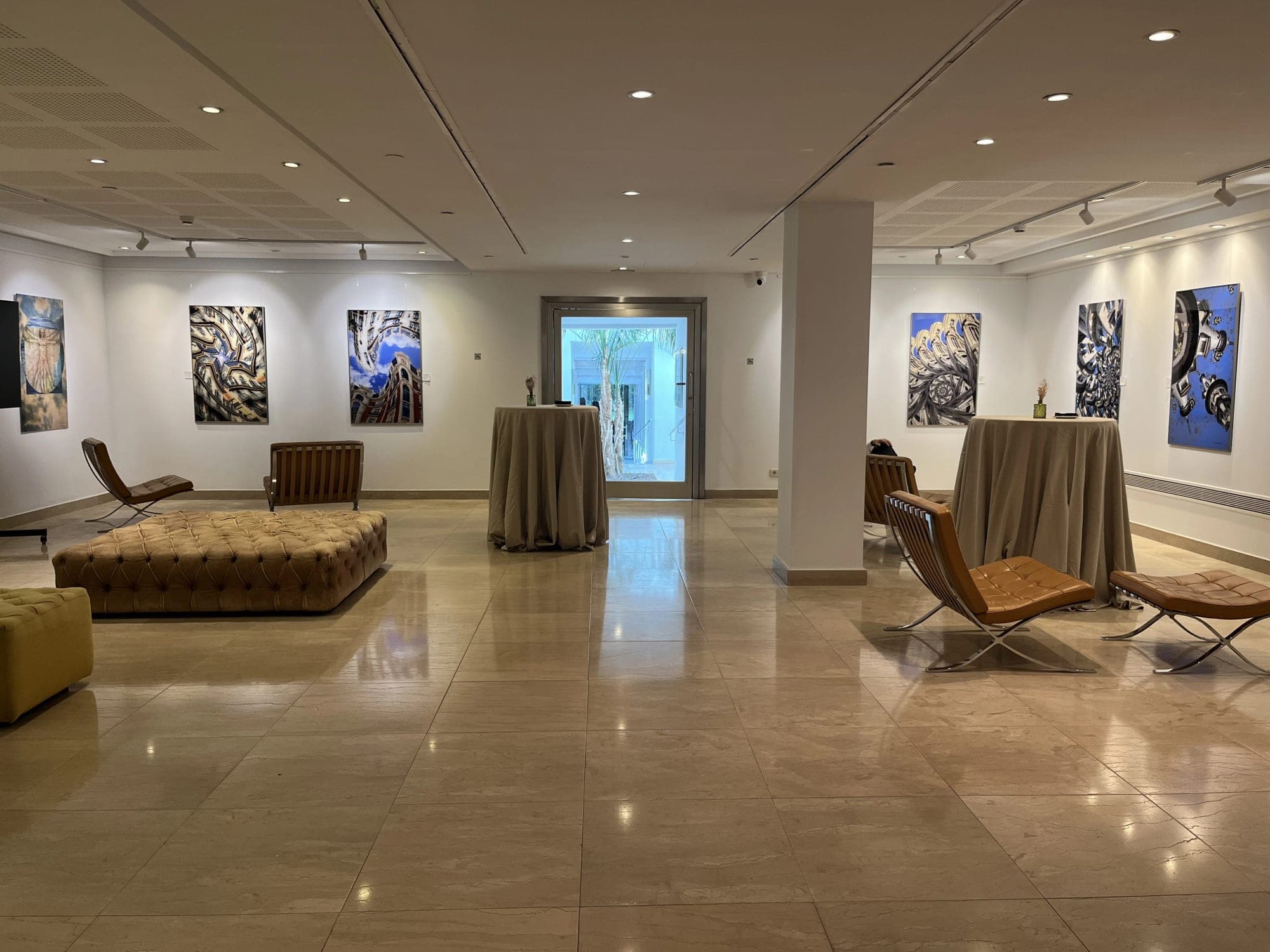 Interior of a venue with art on walls, cocktail tables, and seating.