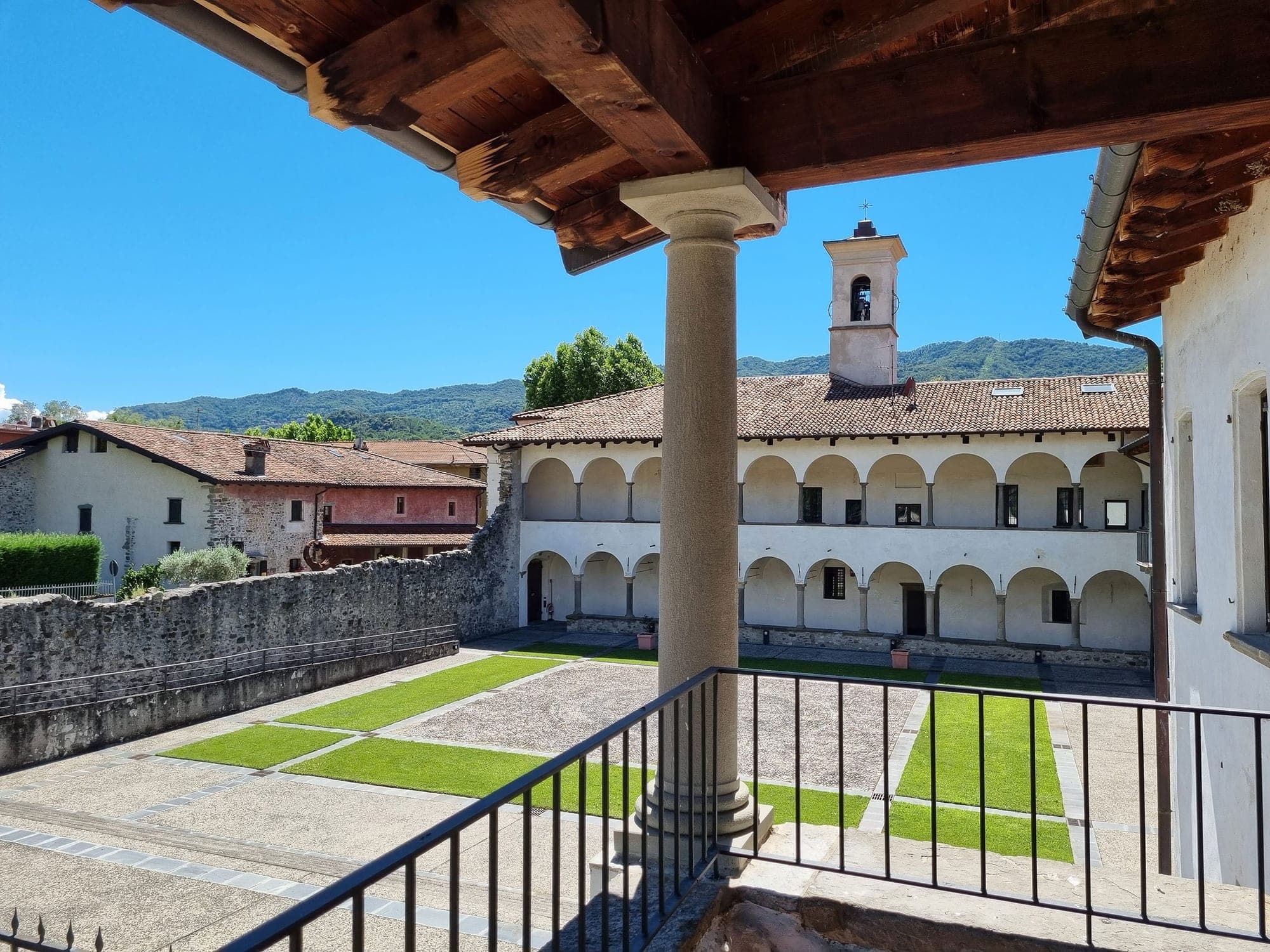 Courtyard with a bell tower and arched walkways at Monastero del Lavello.