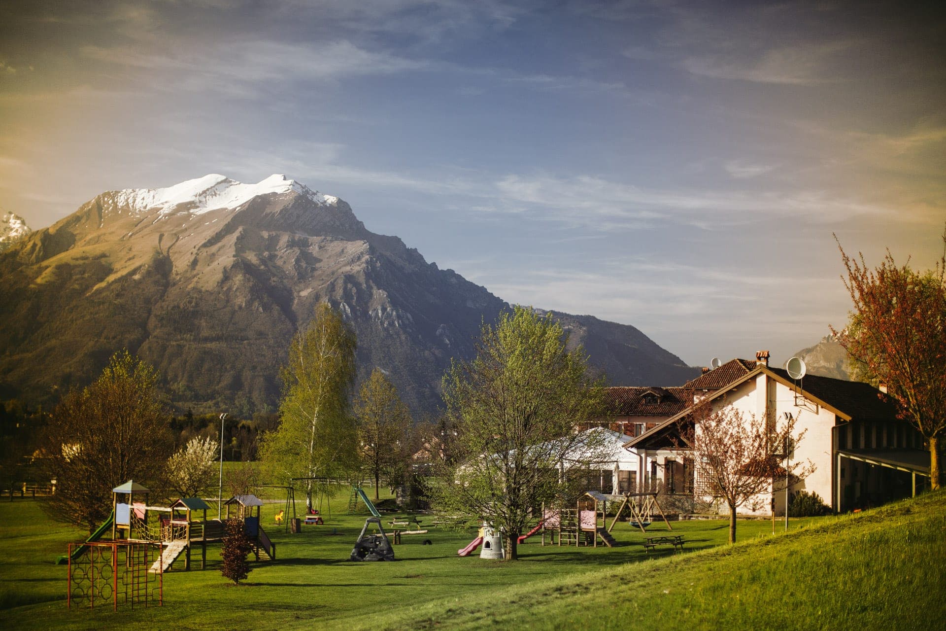 Venue grounds with playground equipment and a mountain in the background.
