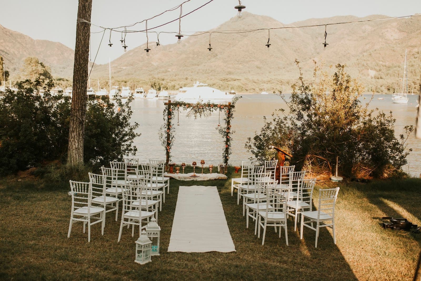 Wedding ceremony setup with chairs and an arch by the water.