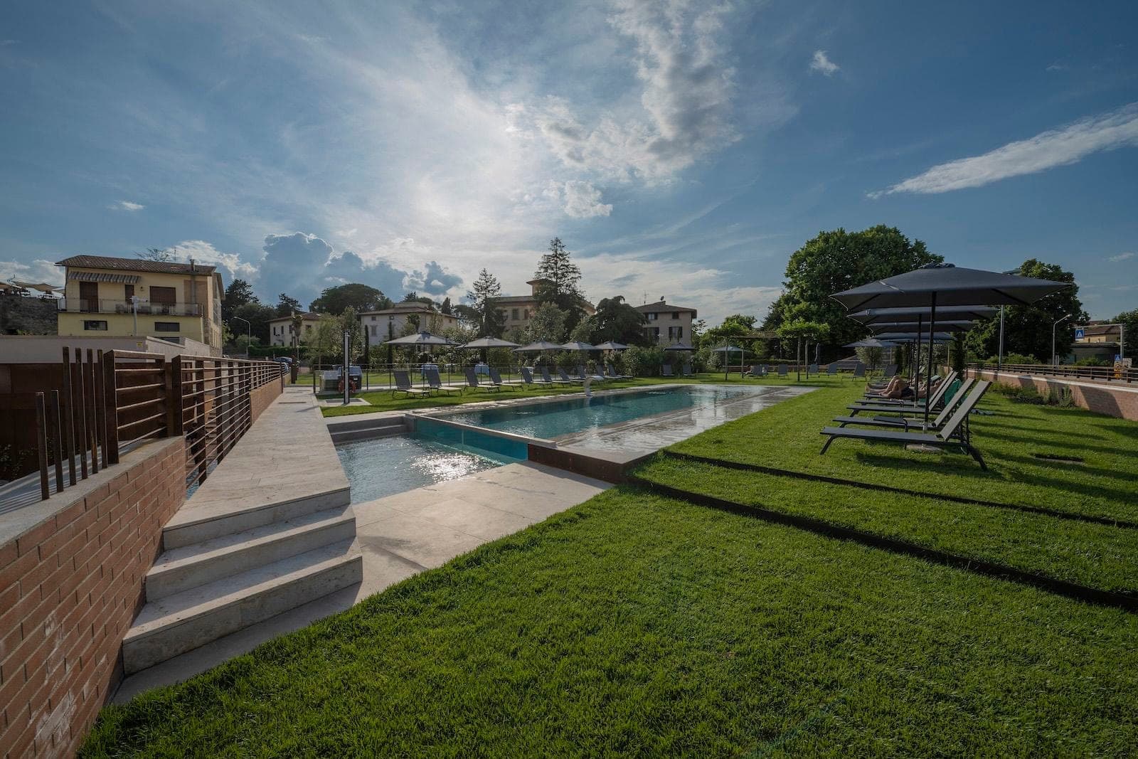 A swimming pool and sun loungers at a venue.