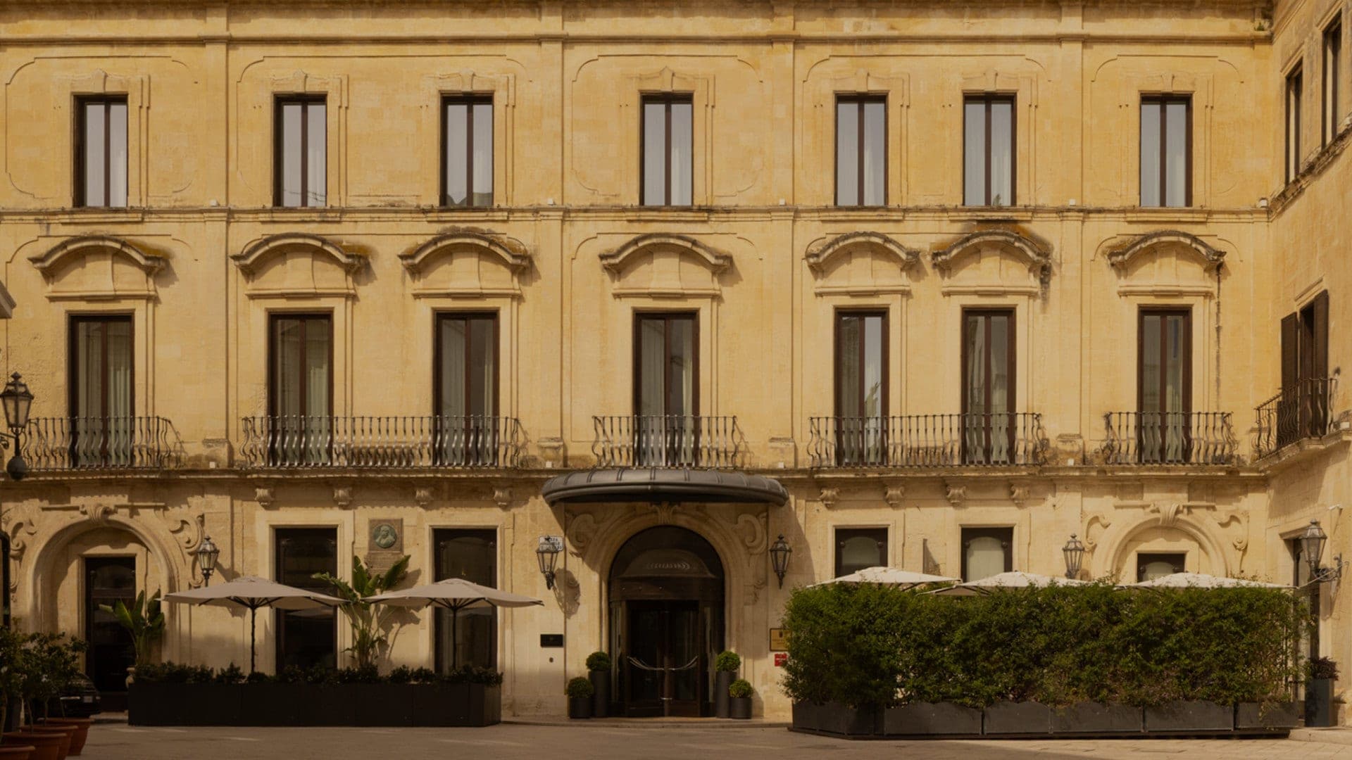 Exterior of a grand yellow building with many windows and balconies.