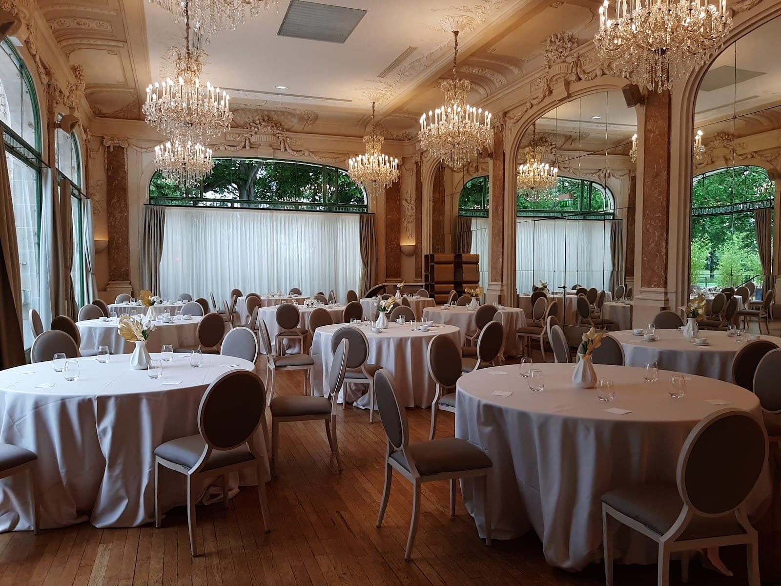 A reception room with round tables set for a wedding.