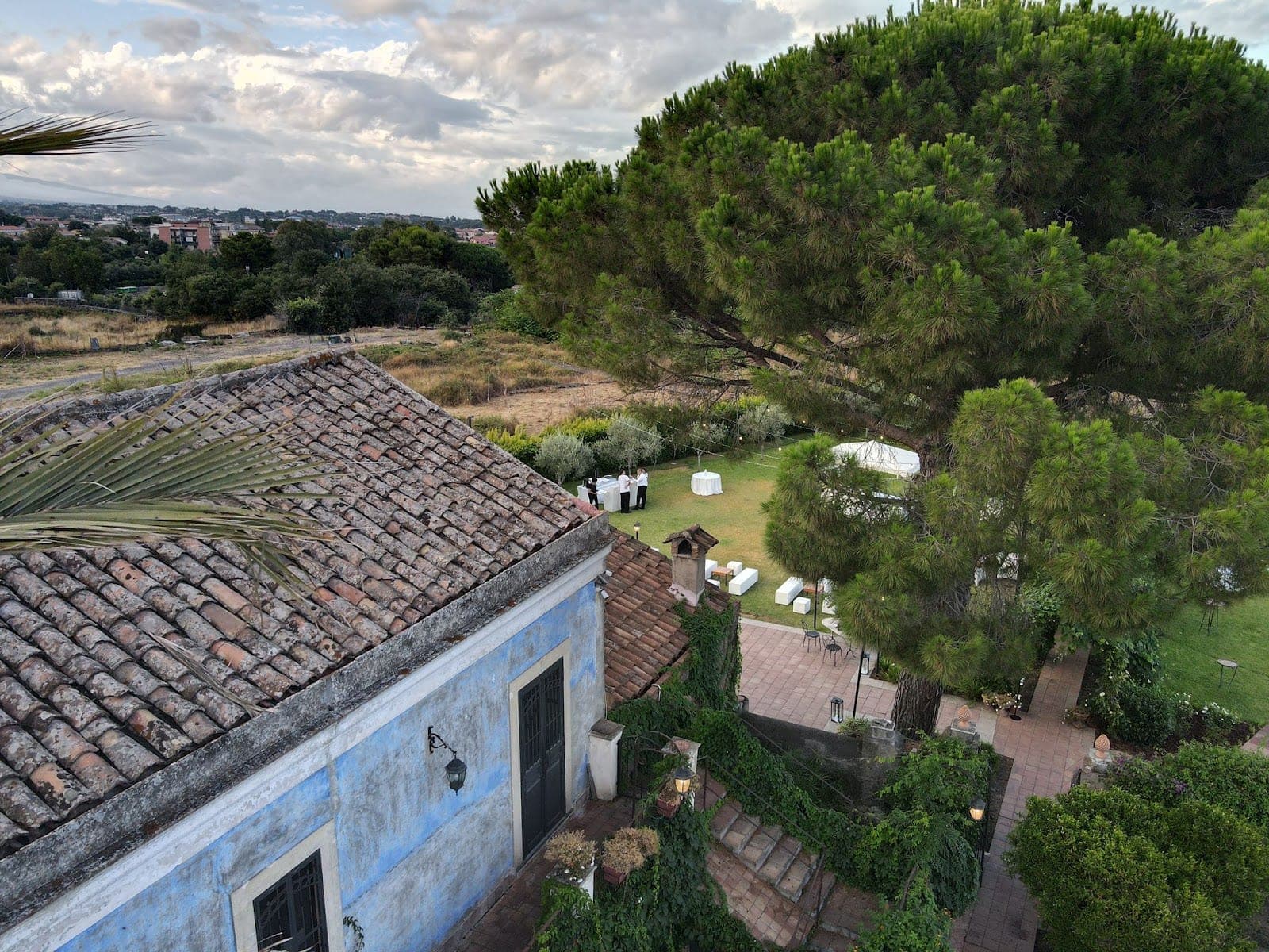A garden with tables set for an event, viewed from above.