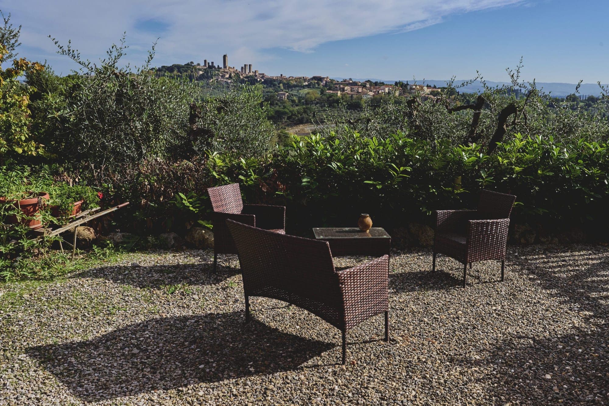 Outdoor seating area with a view of San Gimignano in the distance.