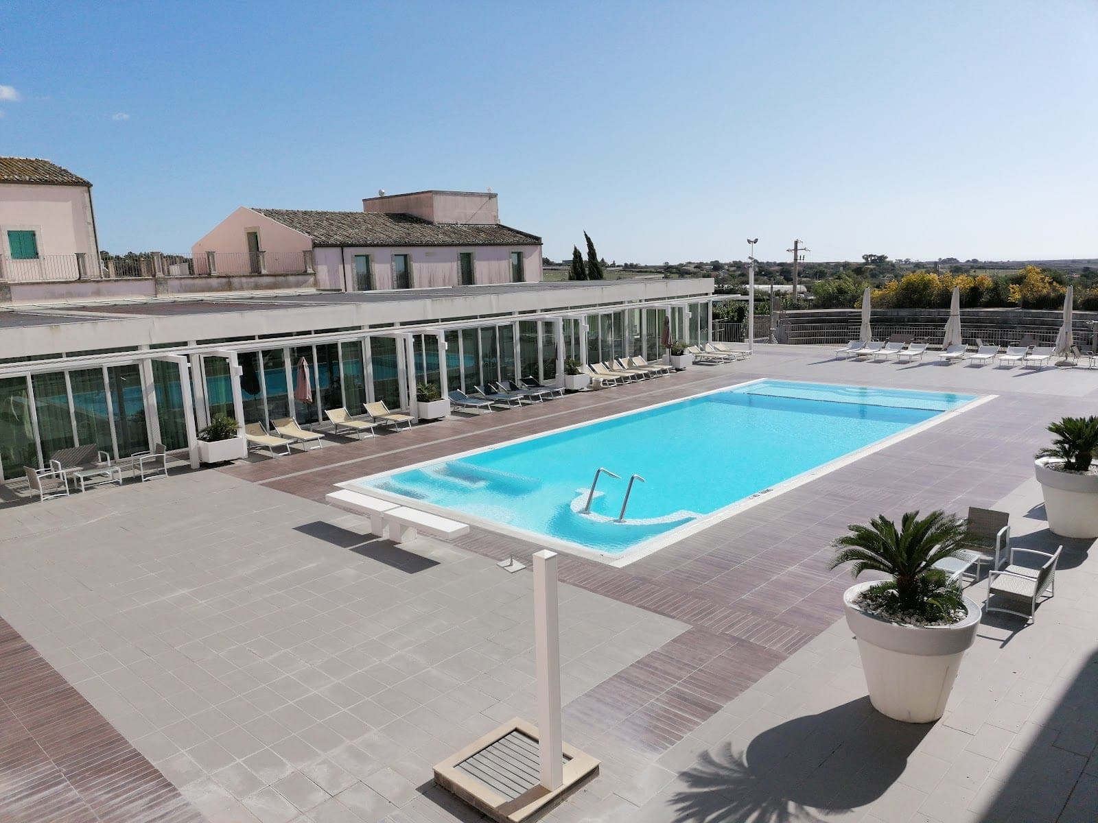 Swimming pool and lounge chairs at a resort on a sunny day.