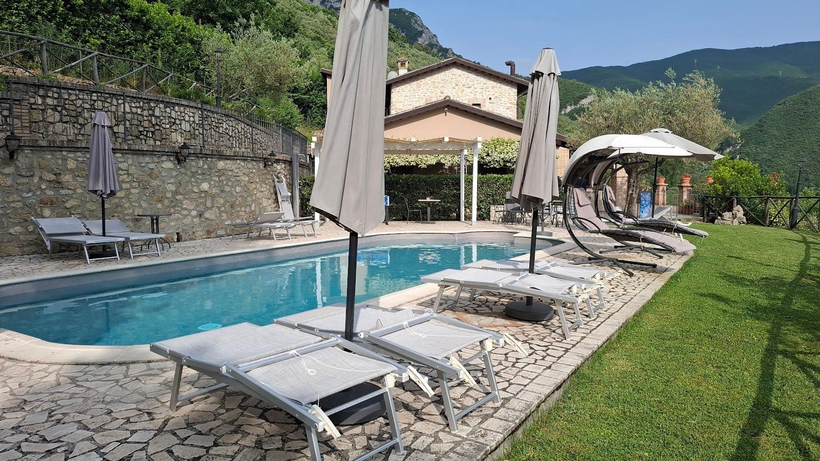 Swimming pool with lounge chairs and umbrellas at a country house.