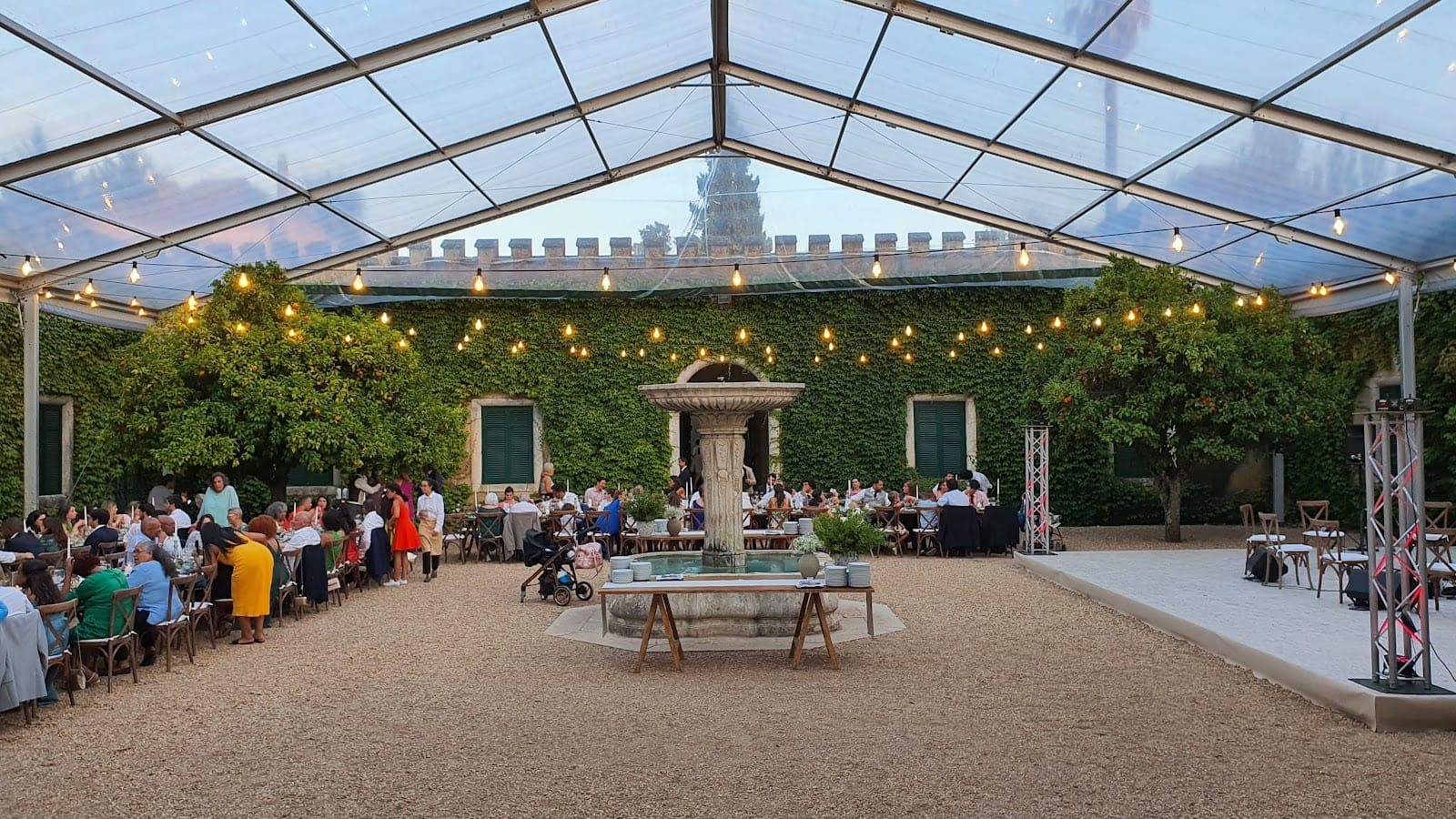 Wedding reception under a marquee with tables and guests.