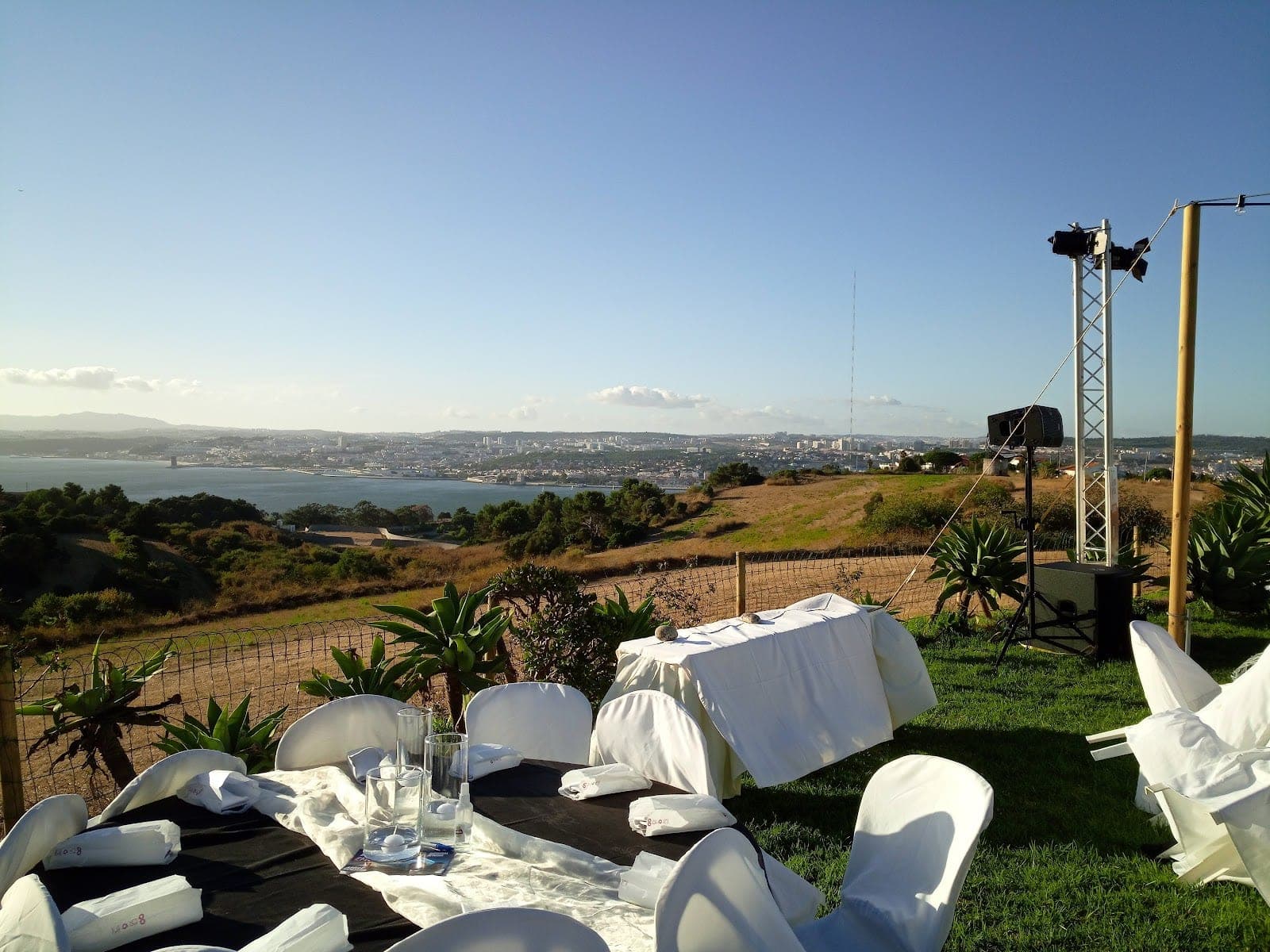Wedding reception table set outdoors with a city and sea view.