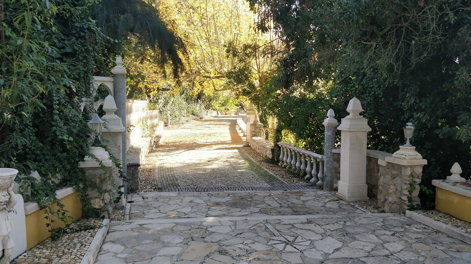 Stone pathway with balustrades and pillars in a garden