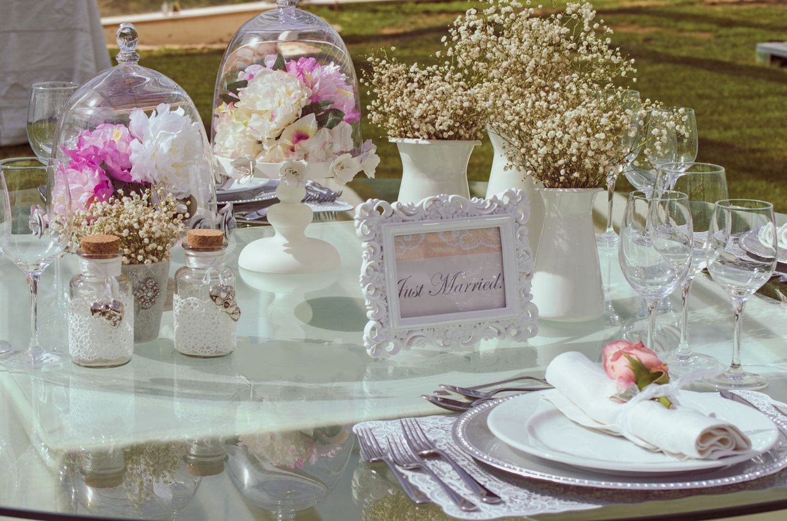A wedding reception table setting with flowers and a "Just Married" sign.