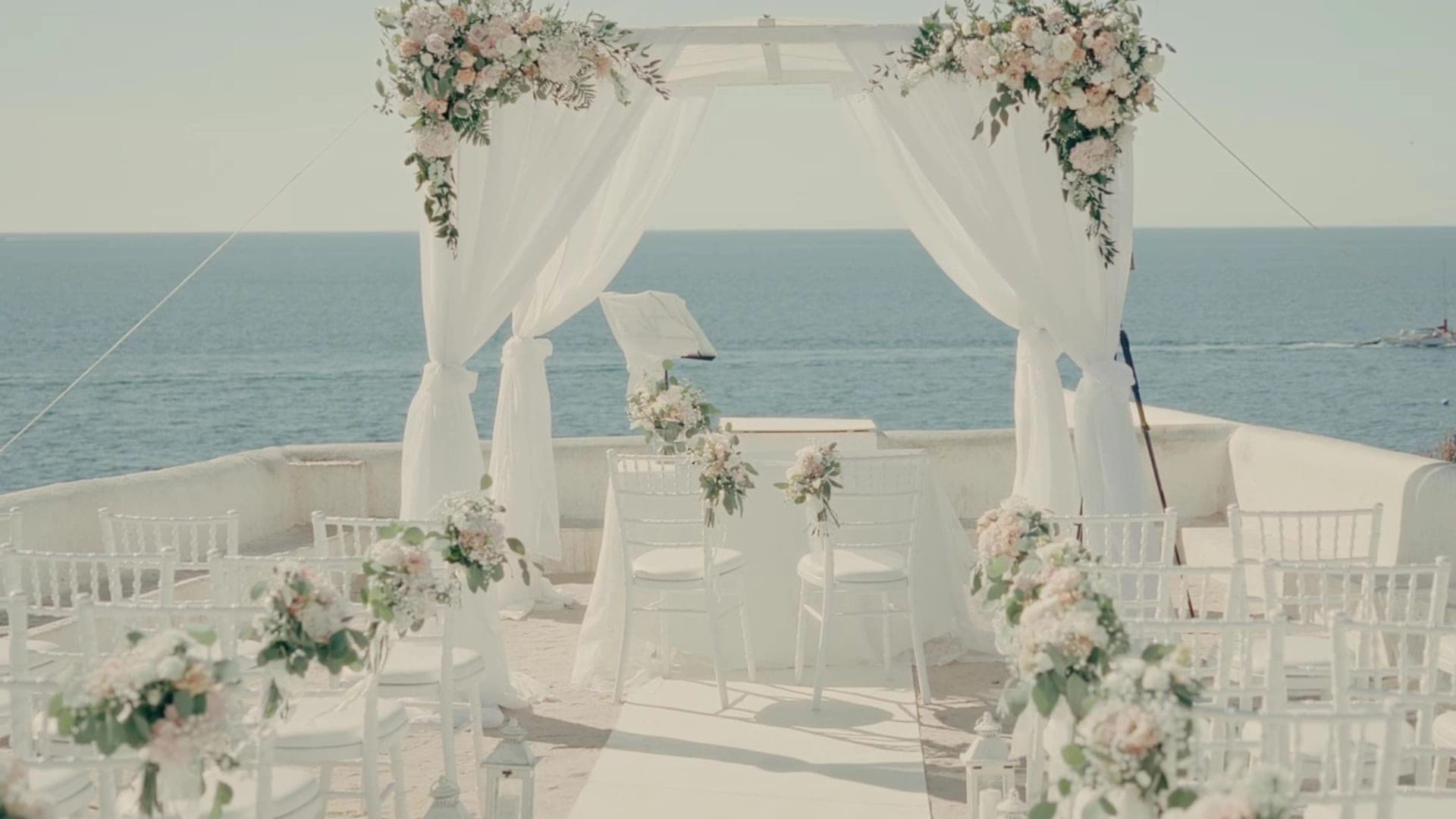 Wedding ceremony setup with chairs and an arch overlooking the ocean.