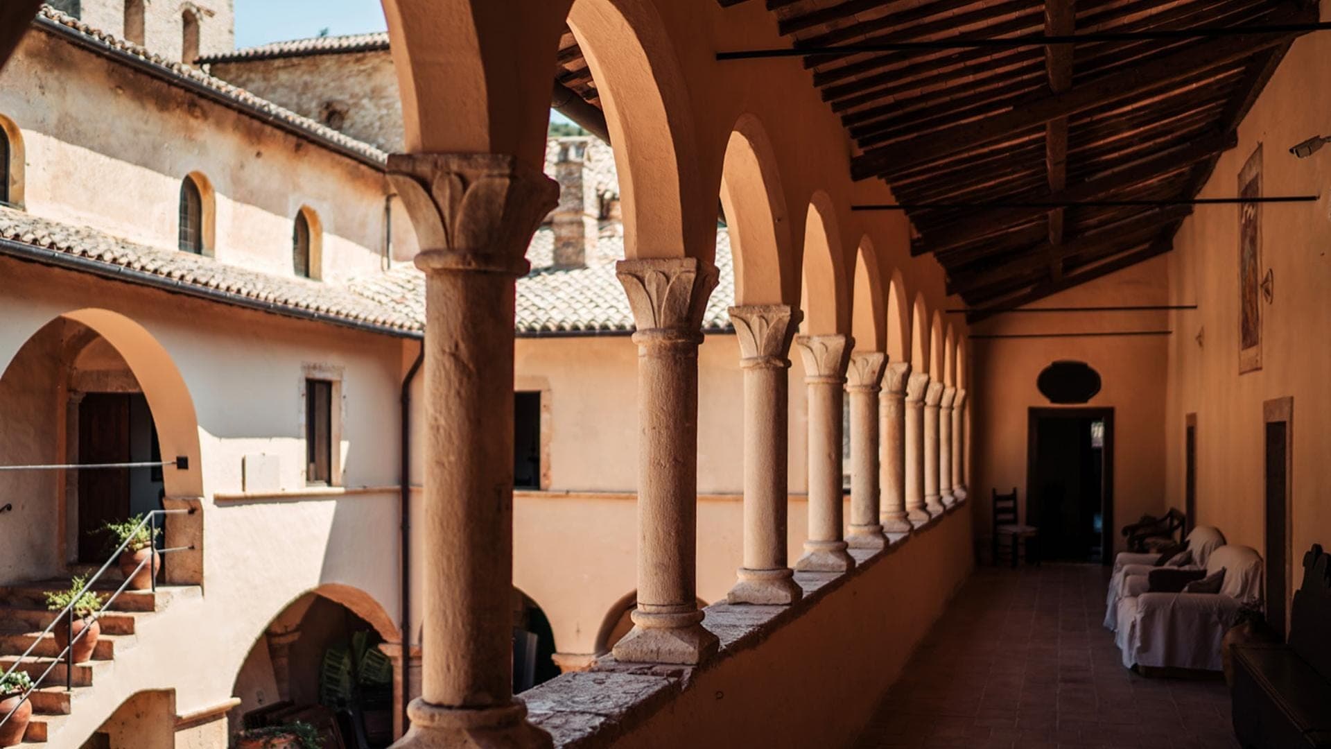 Covered walkway with arches and columns at a historic building.