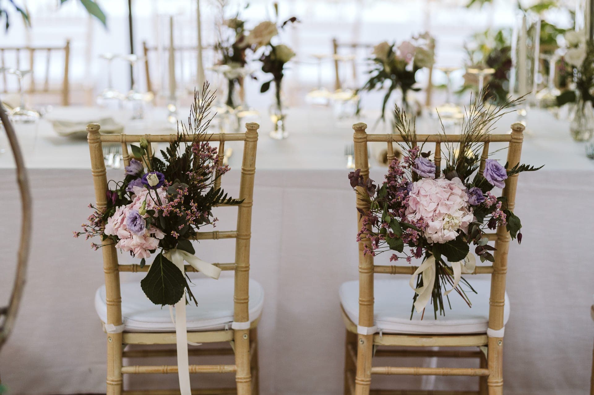 Two chairs decorated with floral arrangements for a wedding ceremony.