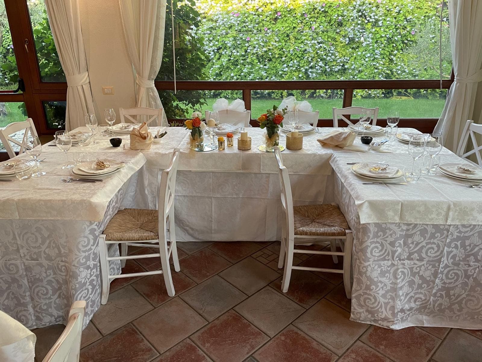 Dining room tables set for a wedding reception with floral centerpieces.