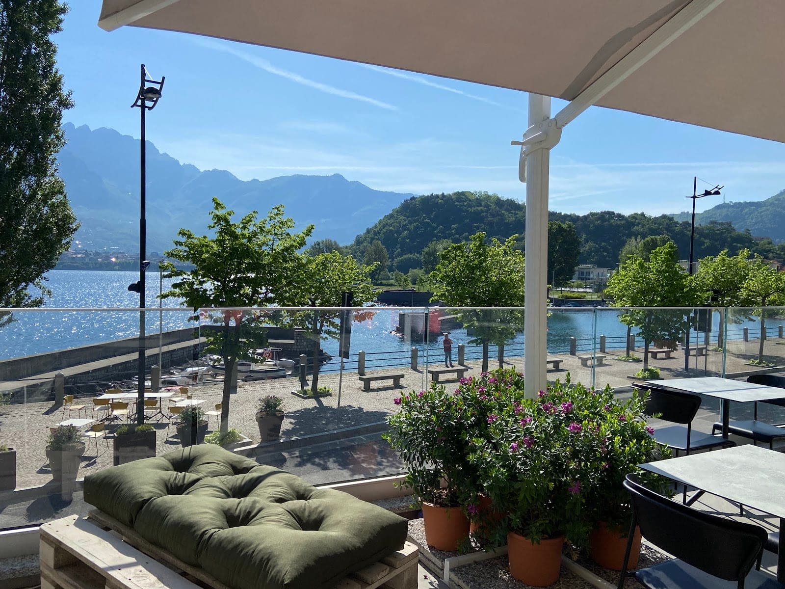 Terrace overlooking a lake with mountains in the background.