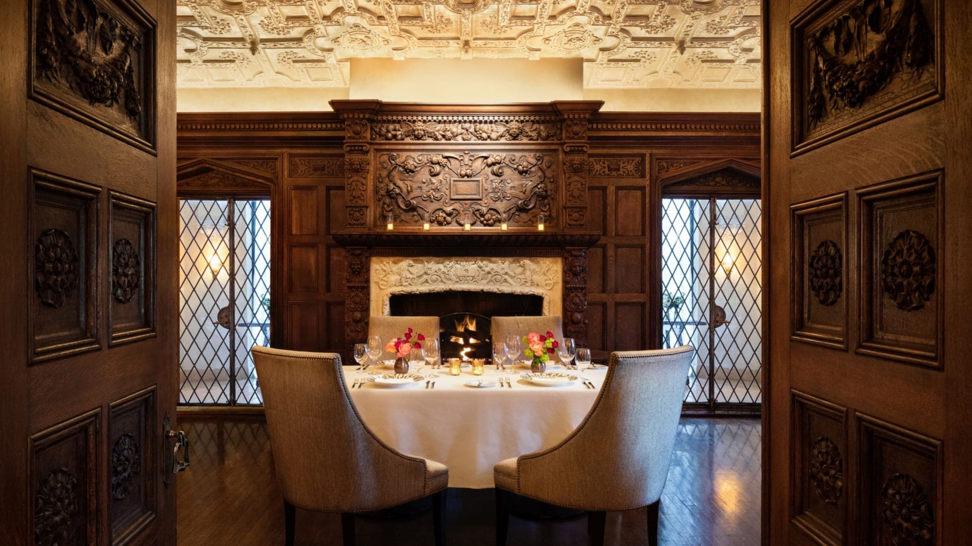 A formal dining table set for a wedding reception in a wood-paneled room.