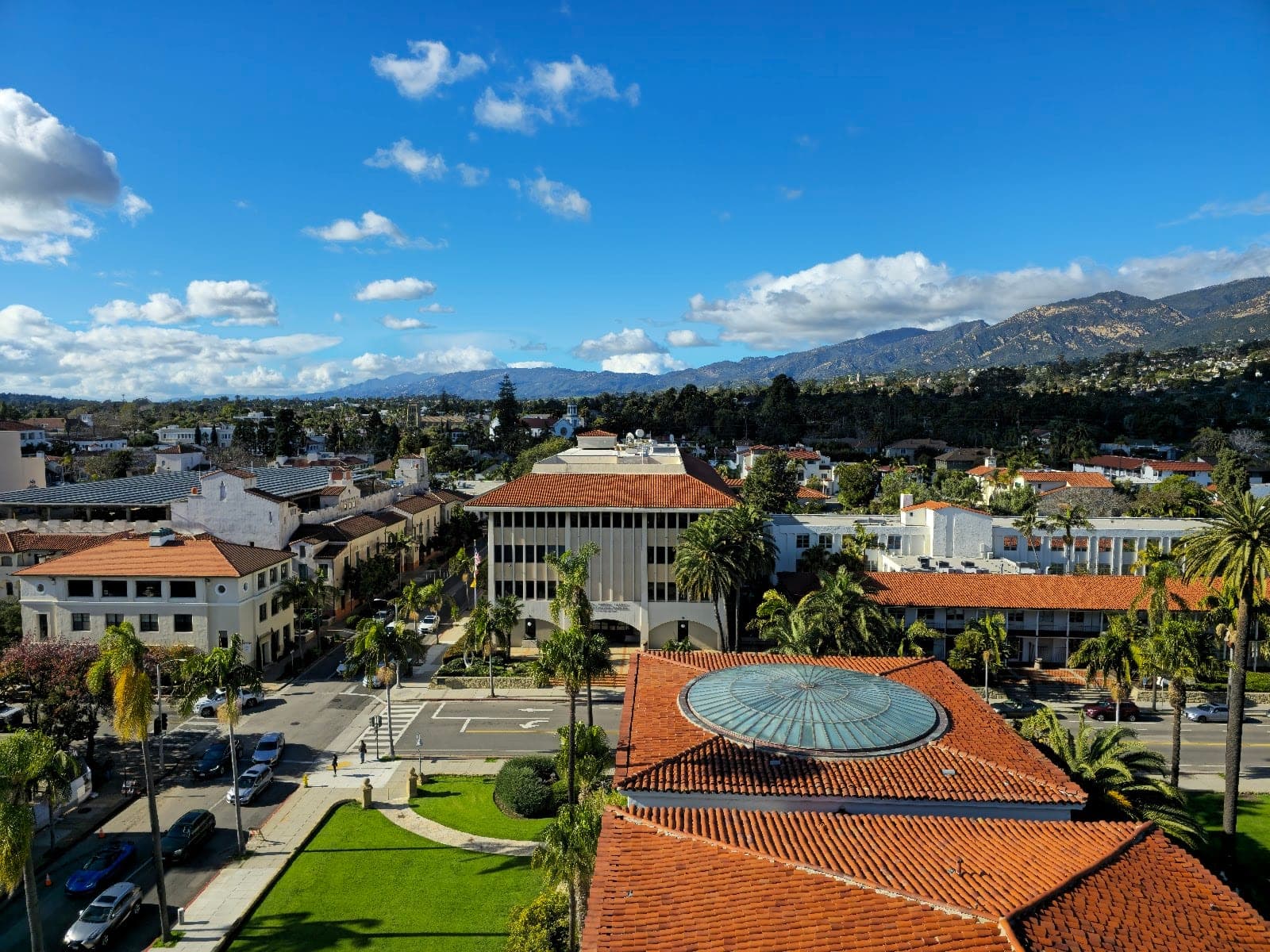 View of Santa Barbara County Courthouse Gardens with surrounding buildings and mountains.