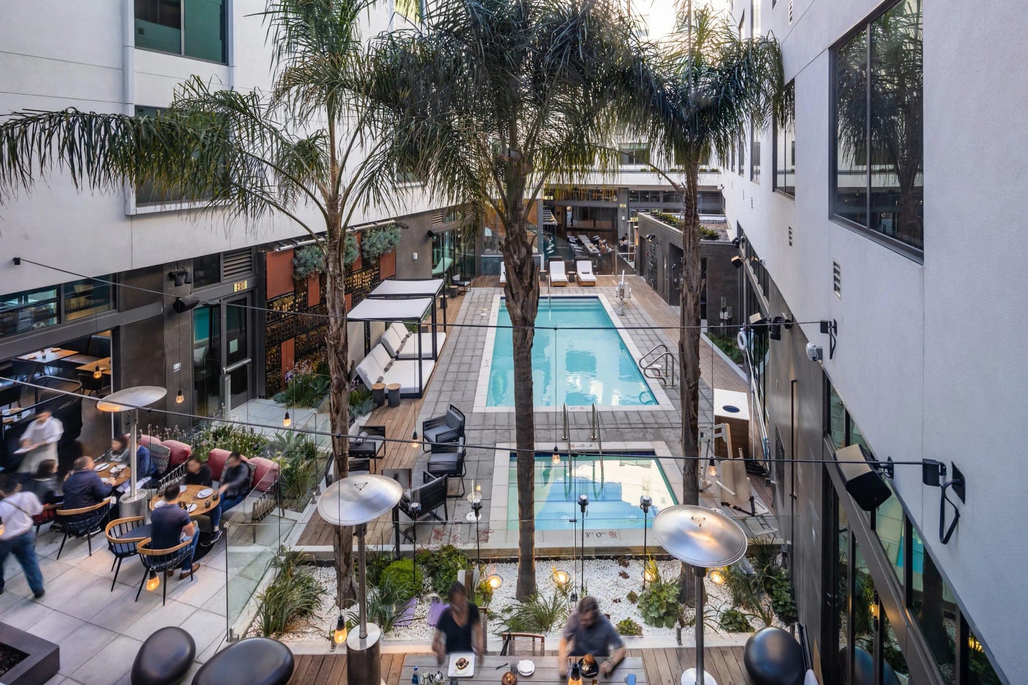 Courtyard with a pool, lounge chairs, and dining tables.