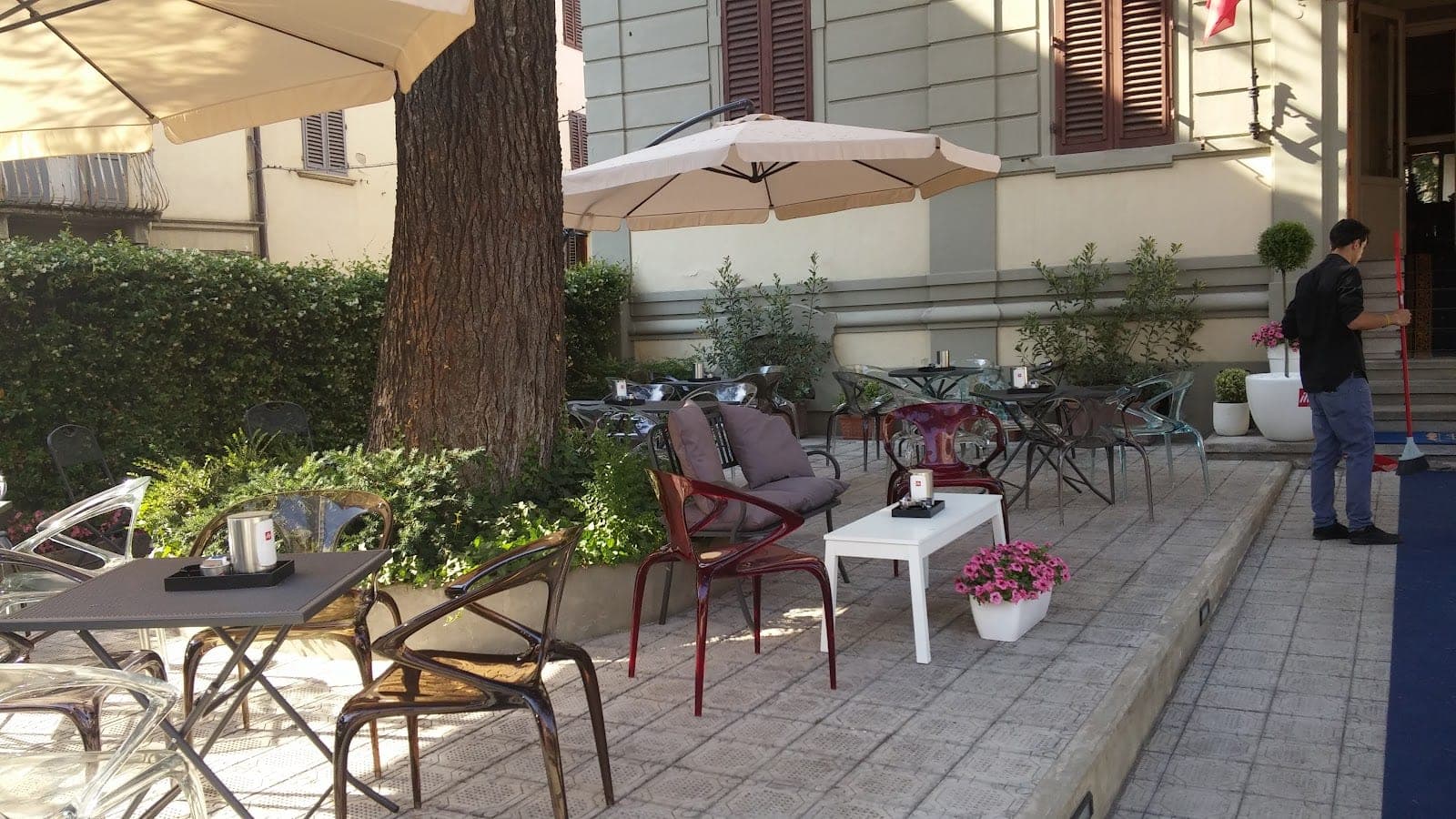 Outdoor seating area with tables, chairs, and umbrellas.