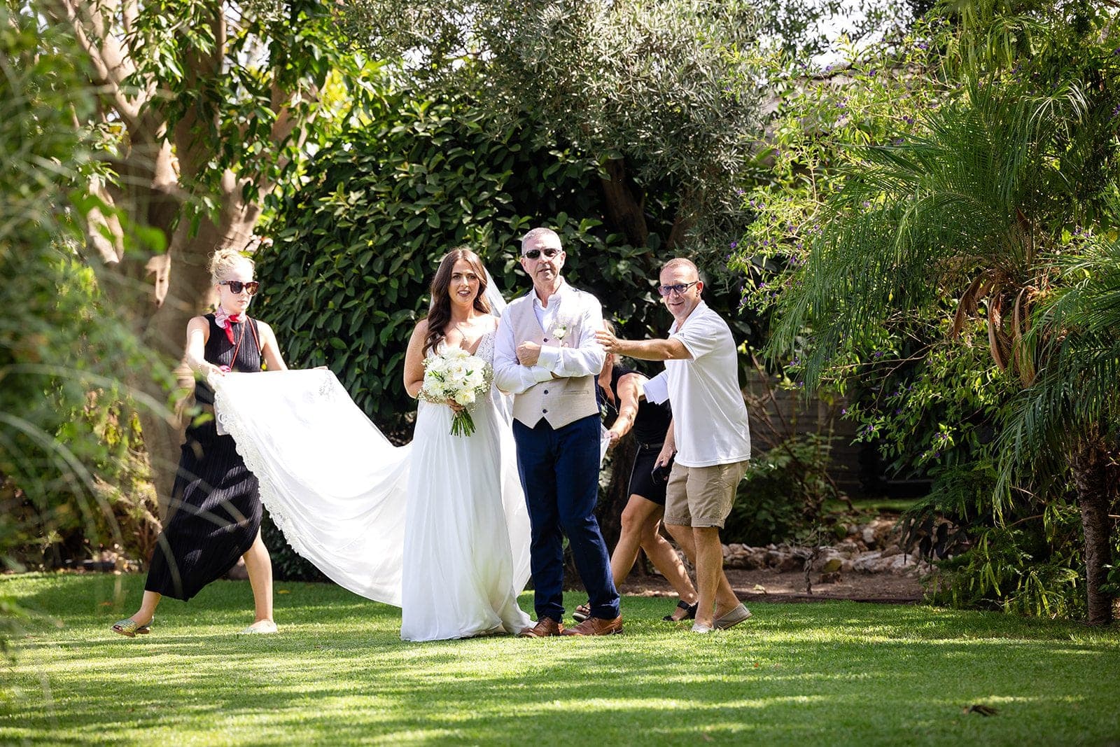 Bride and groom with wedding party in a garden