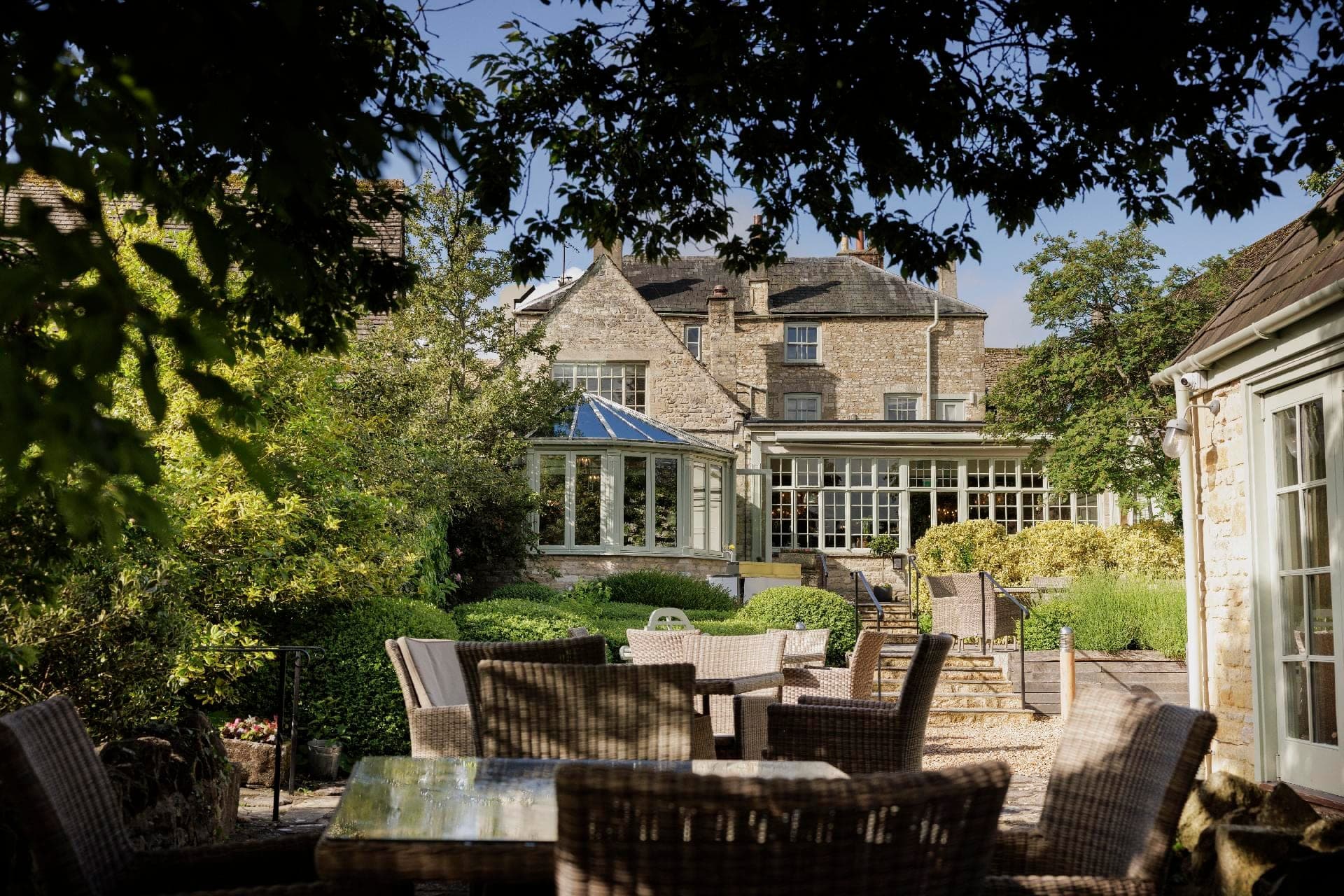 The Bay Tree Hotel exterior with gardens and outdoor seating.