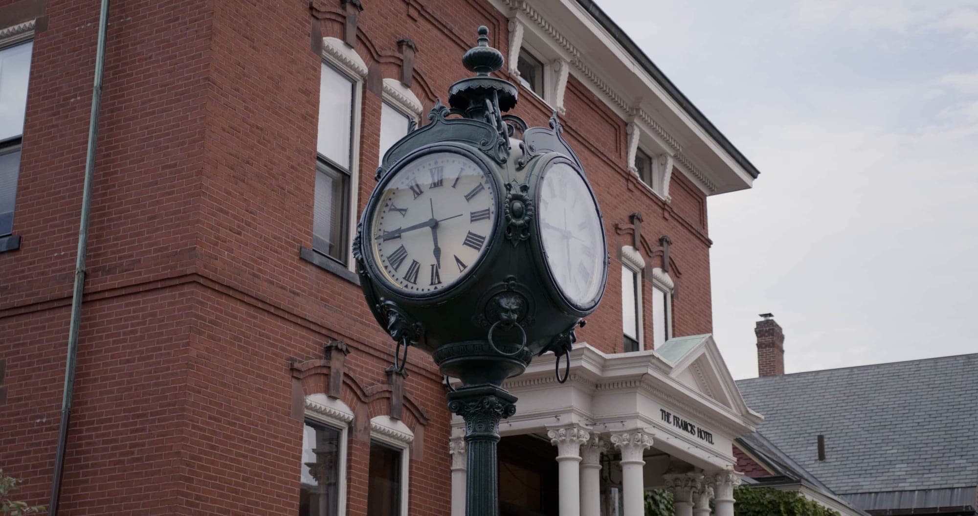Exterior of The Francis Hotel with a large ornate clock in the foreground.