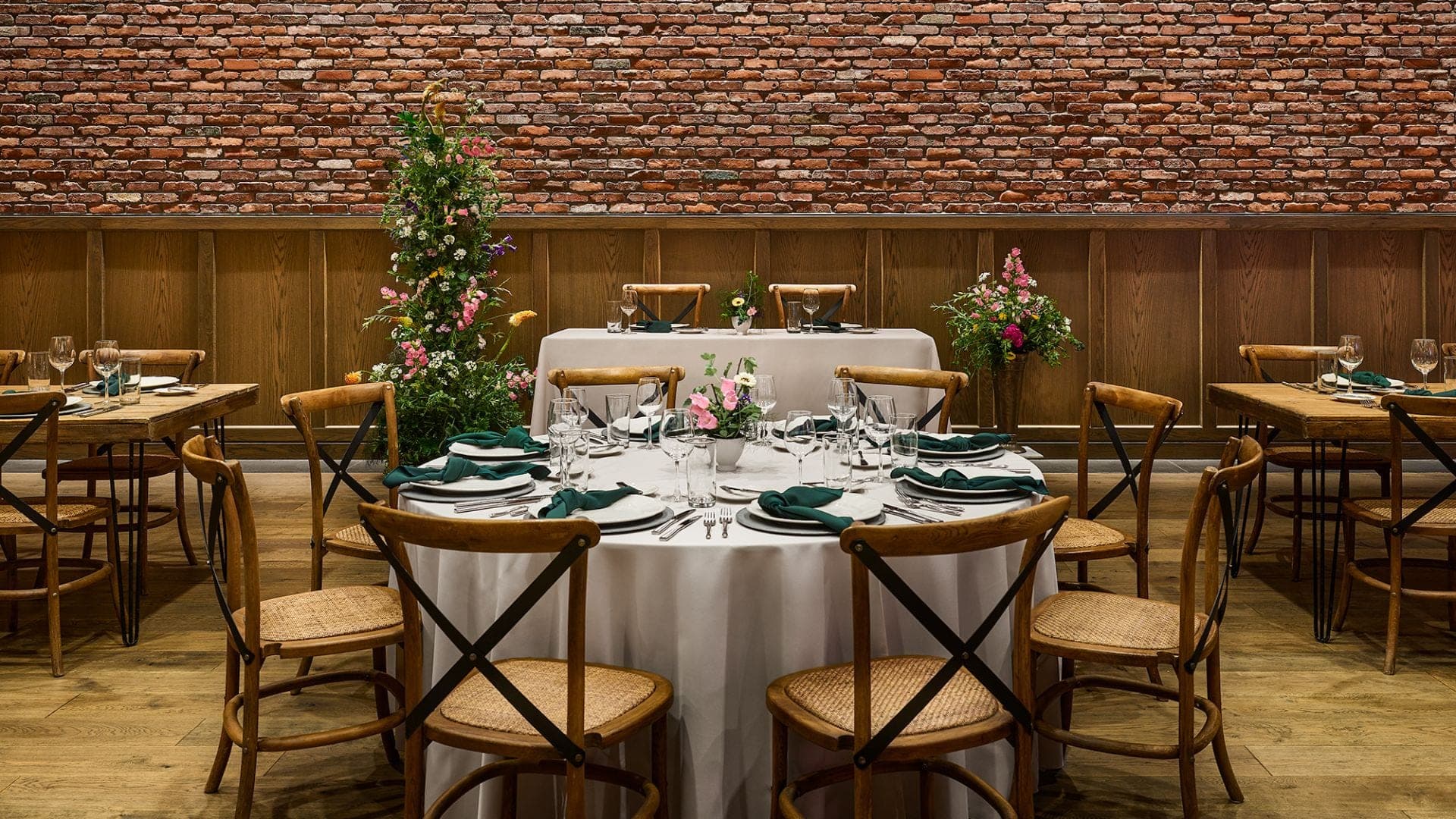 A reception room with round and rectangular tables set for a wedding.