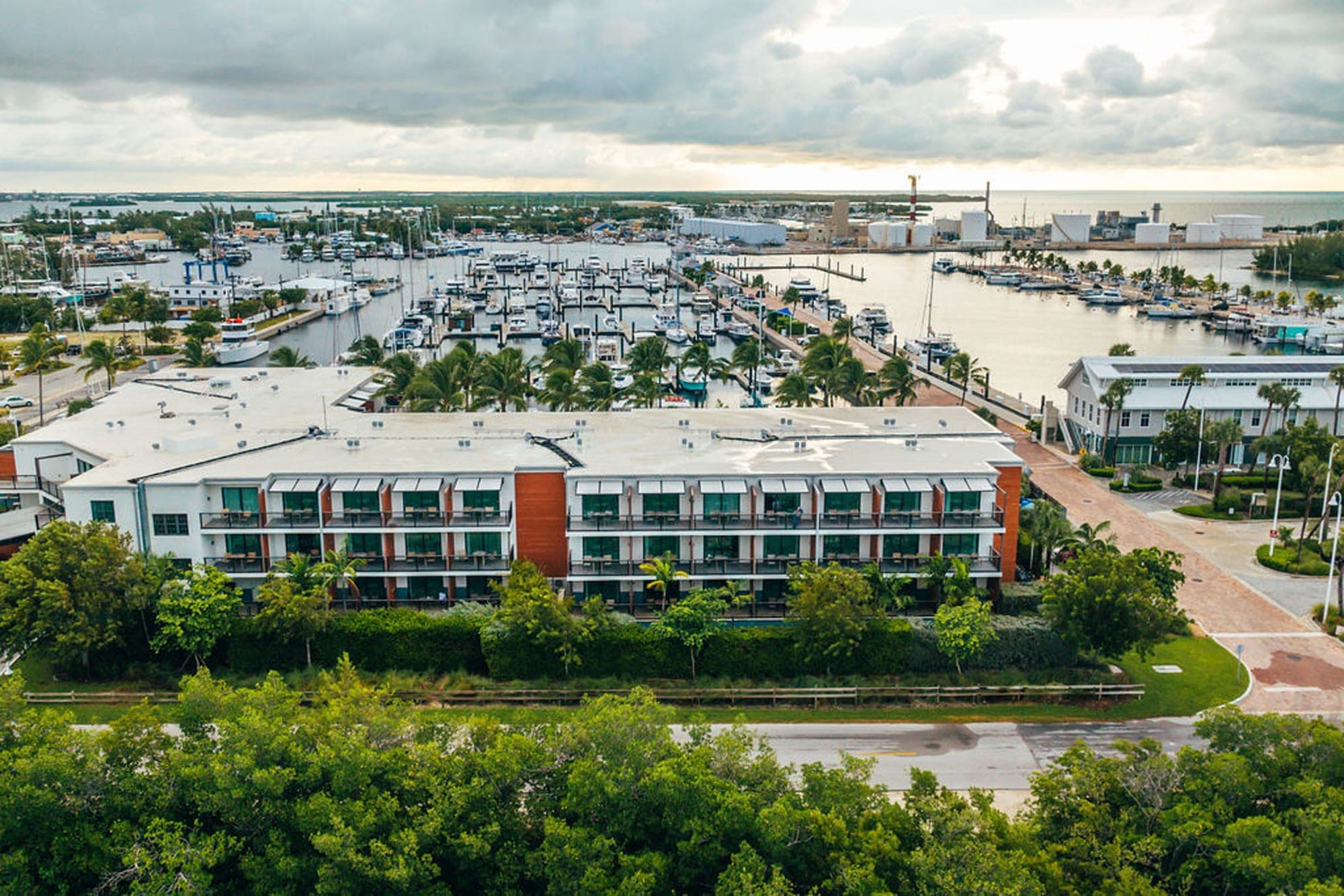 Aerial view of a hotel and marina with many boats docked.