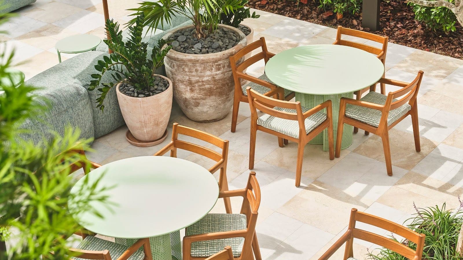 Outdoor seating area with tables, chairs, and plants.