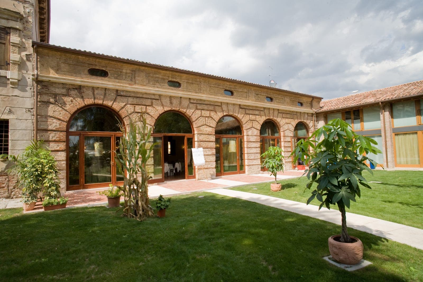 Exterior of a building with arched windows and a green lawn.